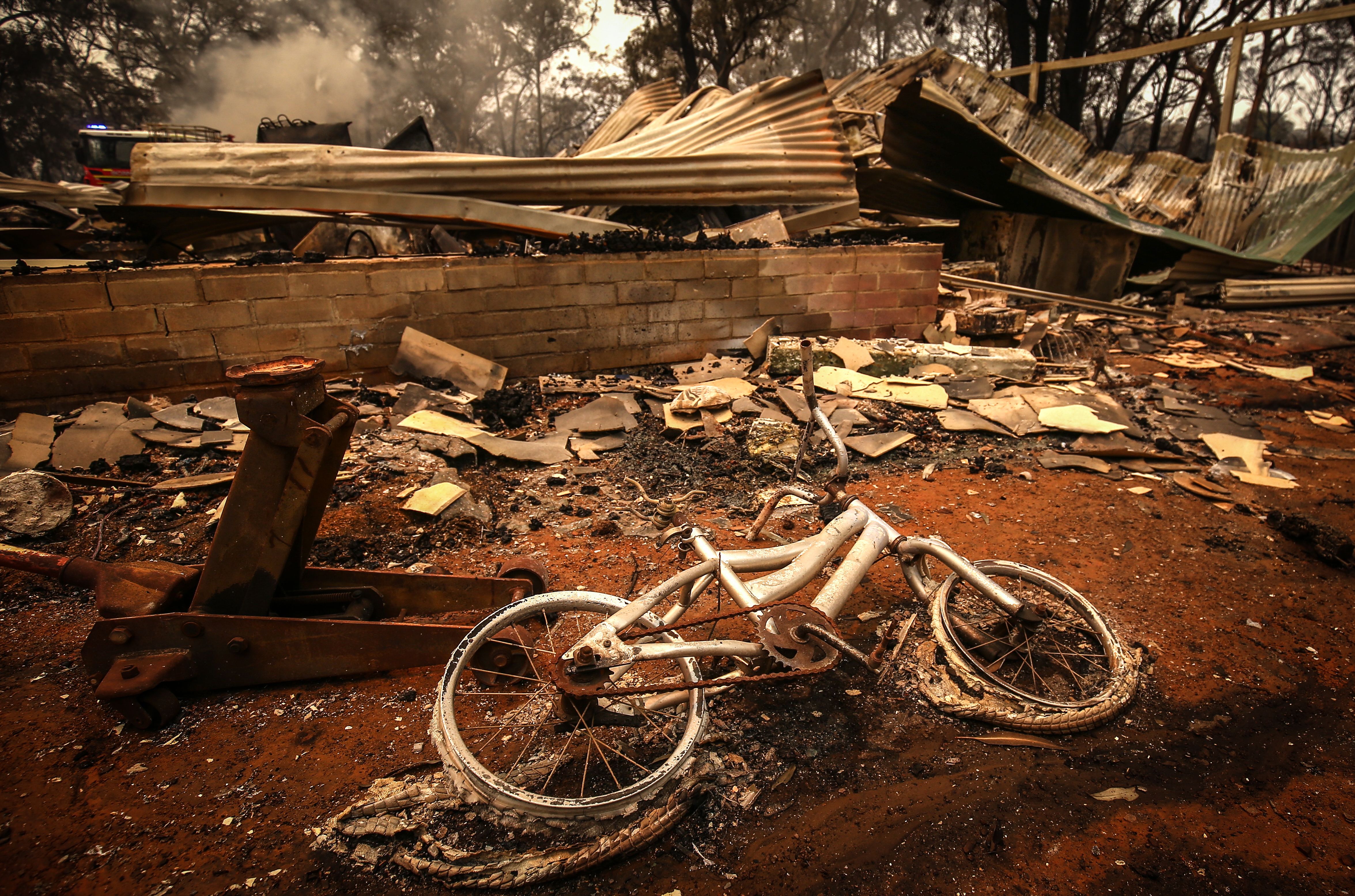 A burnt bicycle lies on the ground in front of a house recently destroyed by bushfires on the outskirts of the town of Bargo on December 21, 2019 in Sydney