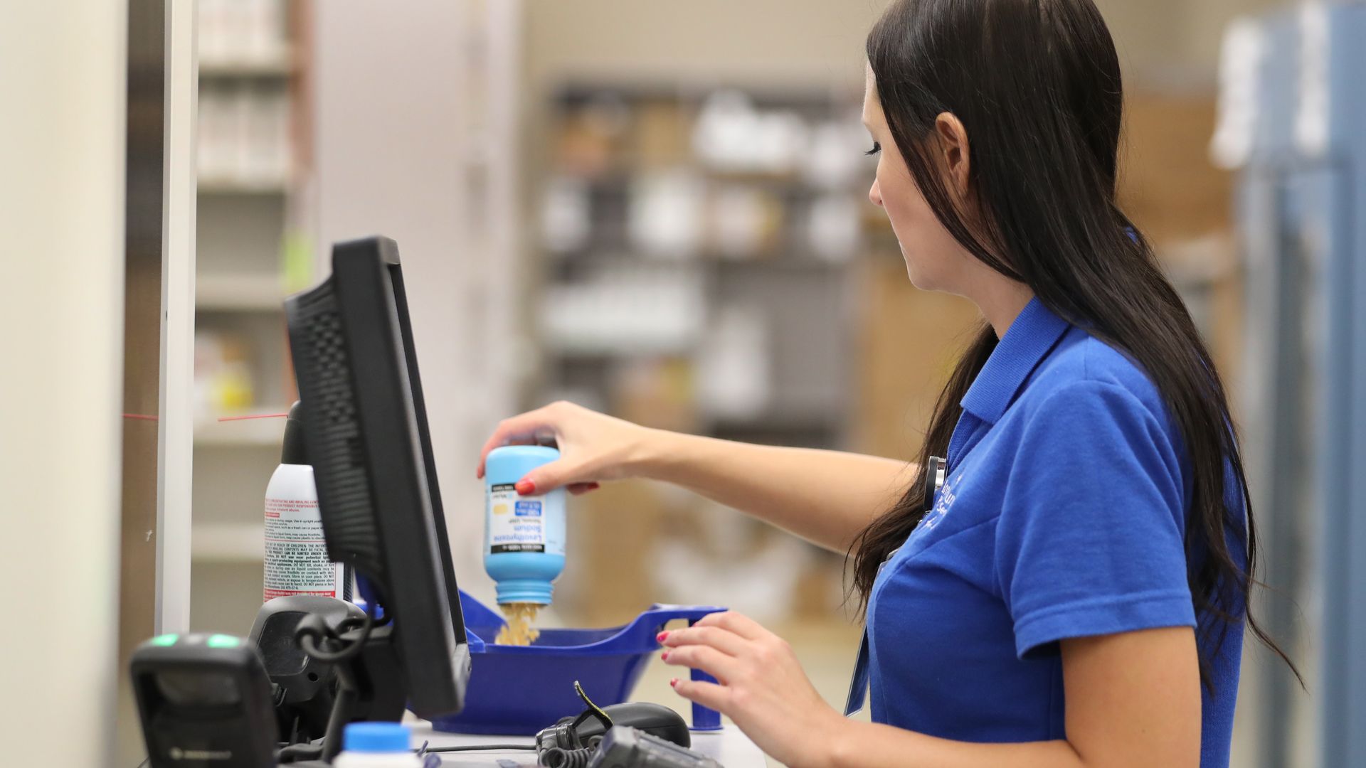 Pharmacist measuring pills