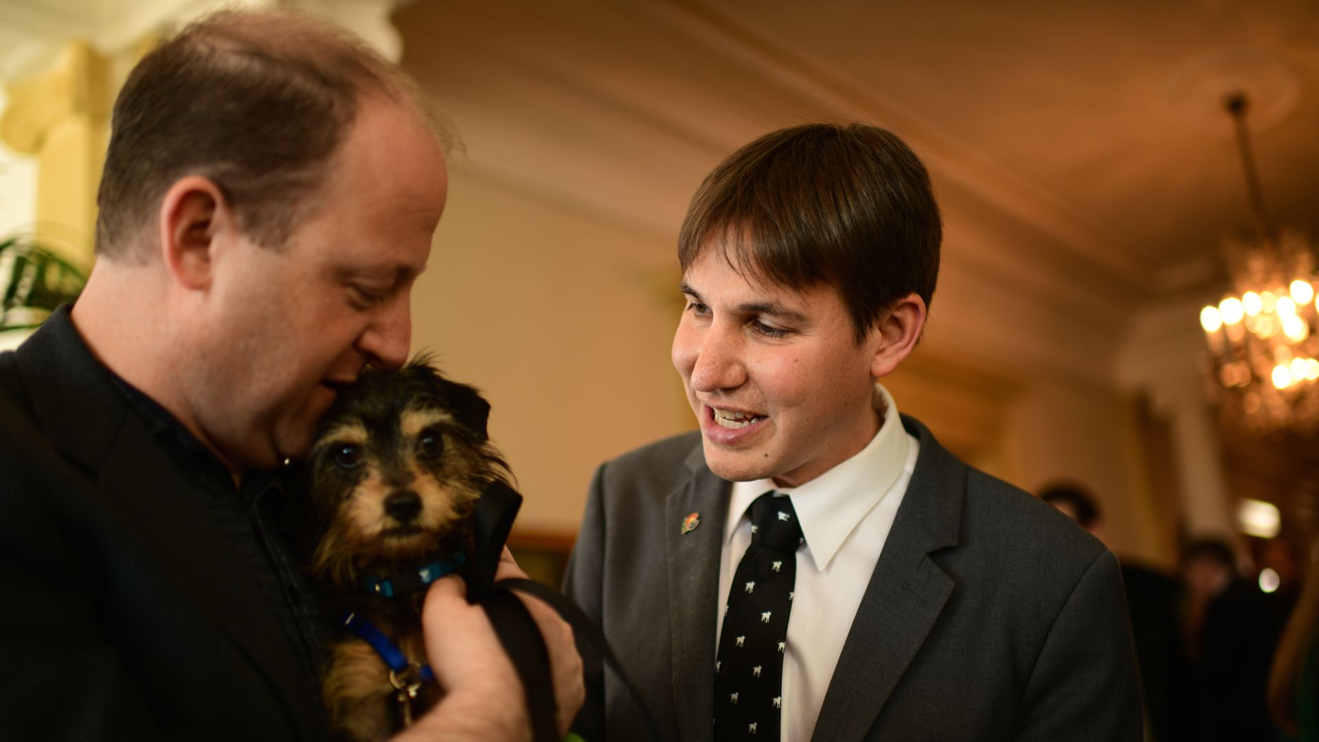Colorado Governor Jared Polis and his partner Marlon Reis with a terrier.