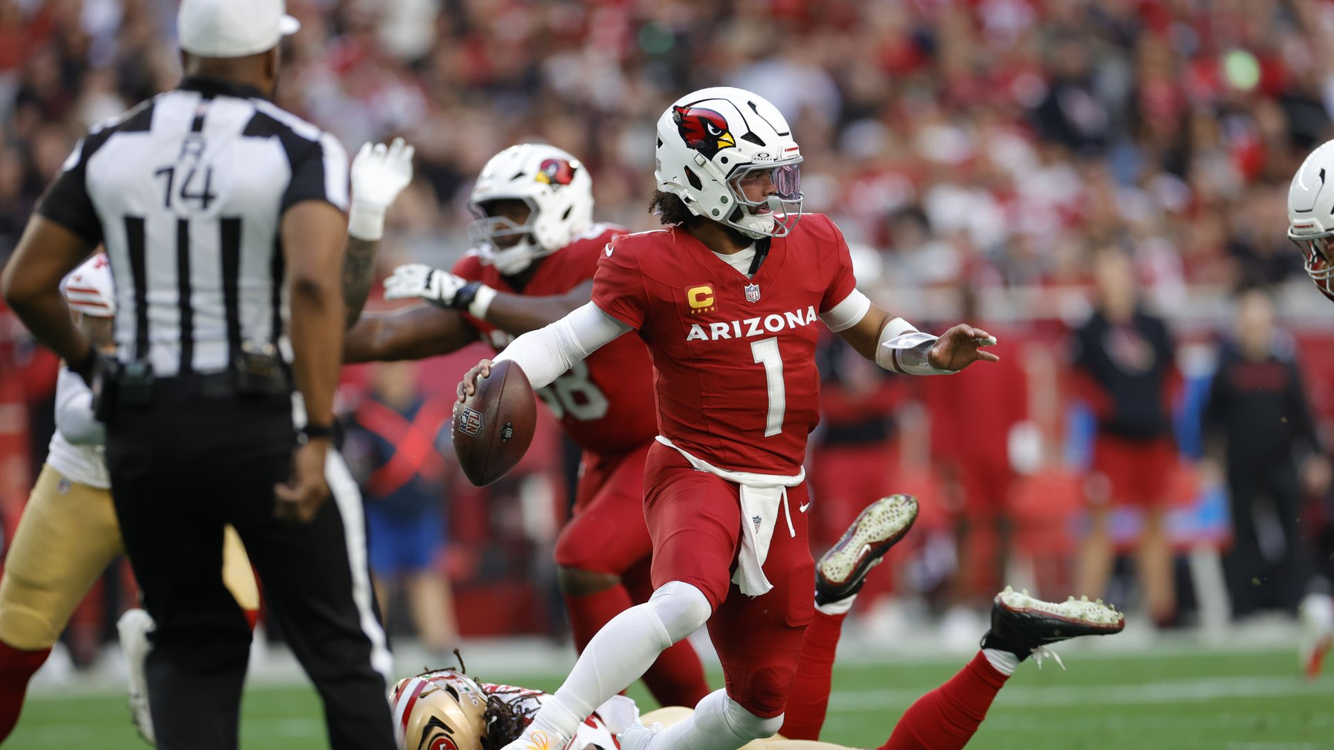 Kyler Murray scrambles with the football after dodging a tackle. 