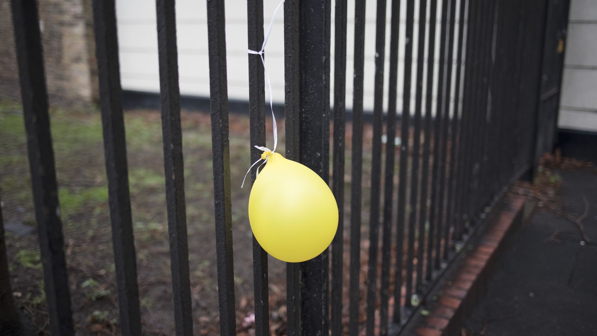 Yellow party balloon attached to railings in London, England, United Kingdom. (photo by Mike Kemp/In Pictures via Getty Images Images)