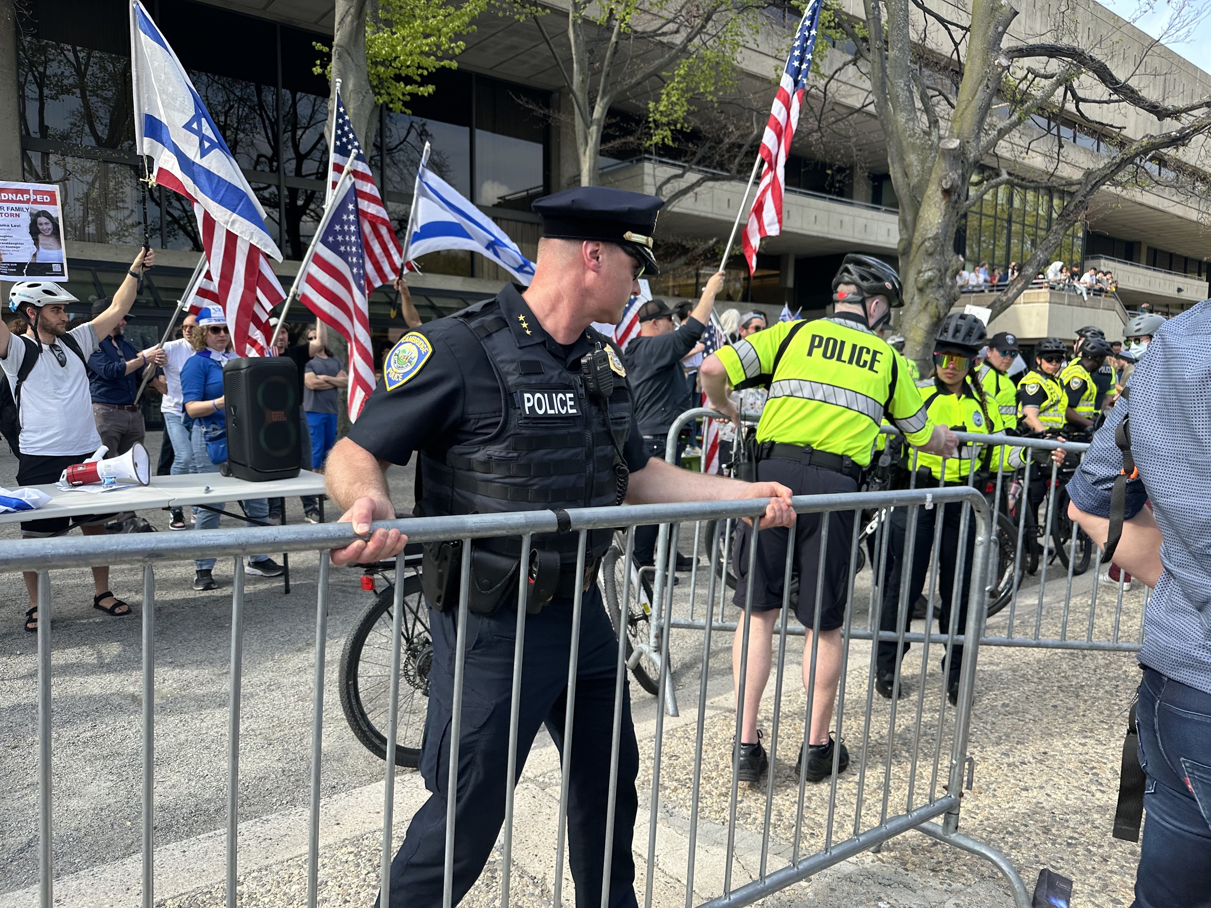 A Cambridge police officer moves a barricade between pro-Israel protesters and pro-Palestine protesters as hundreds, perhaps thousands, swarm MIT's campus Monday, May 6, 2024.  