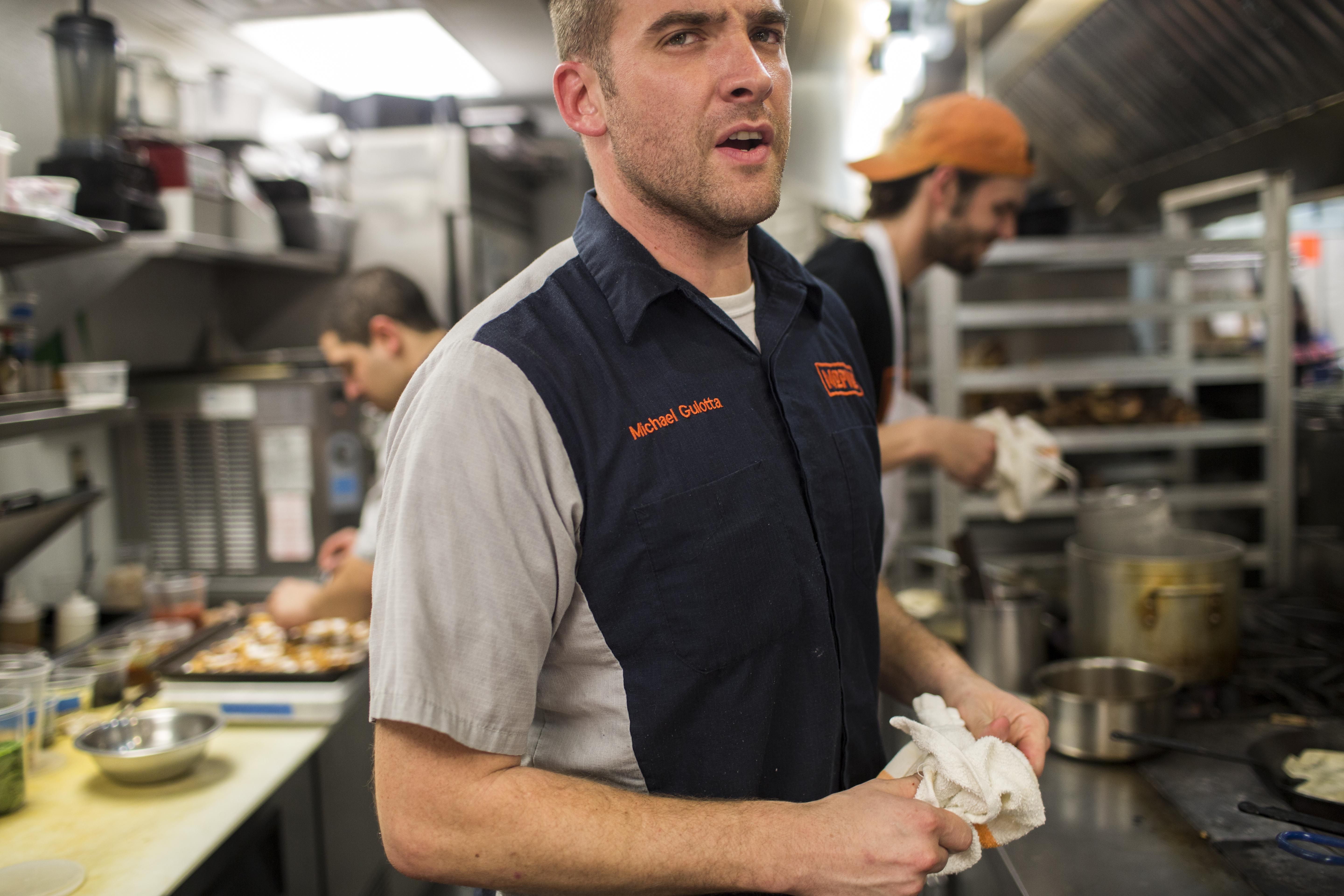 A photo of chef Michael Gulotta in the kitchen at Mopho.
