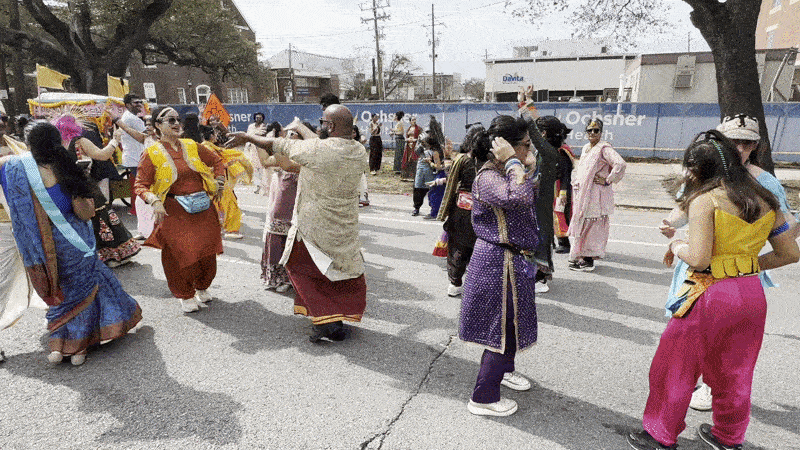Image shows people dancing on the street.