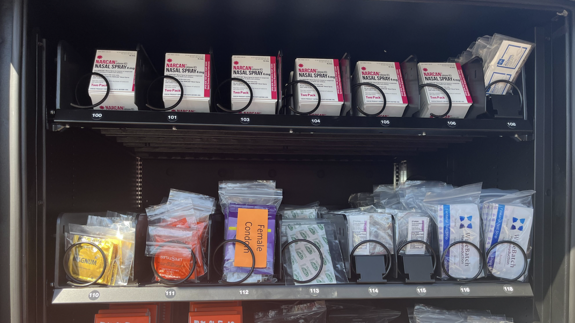 The inside of a vending machine, showing Narcan, condoms, and antibiotic ointment. 
