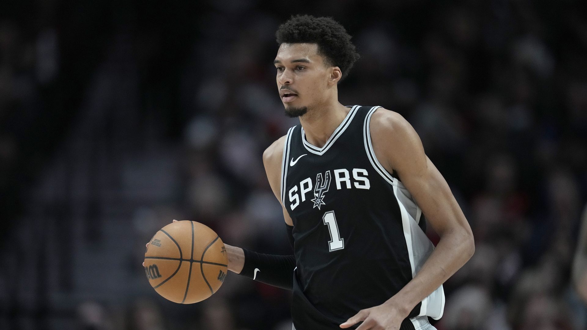 Victor Wembanyama palms a basketball mid-game.