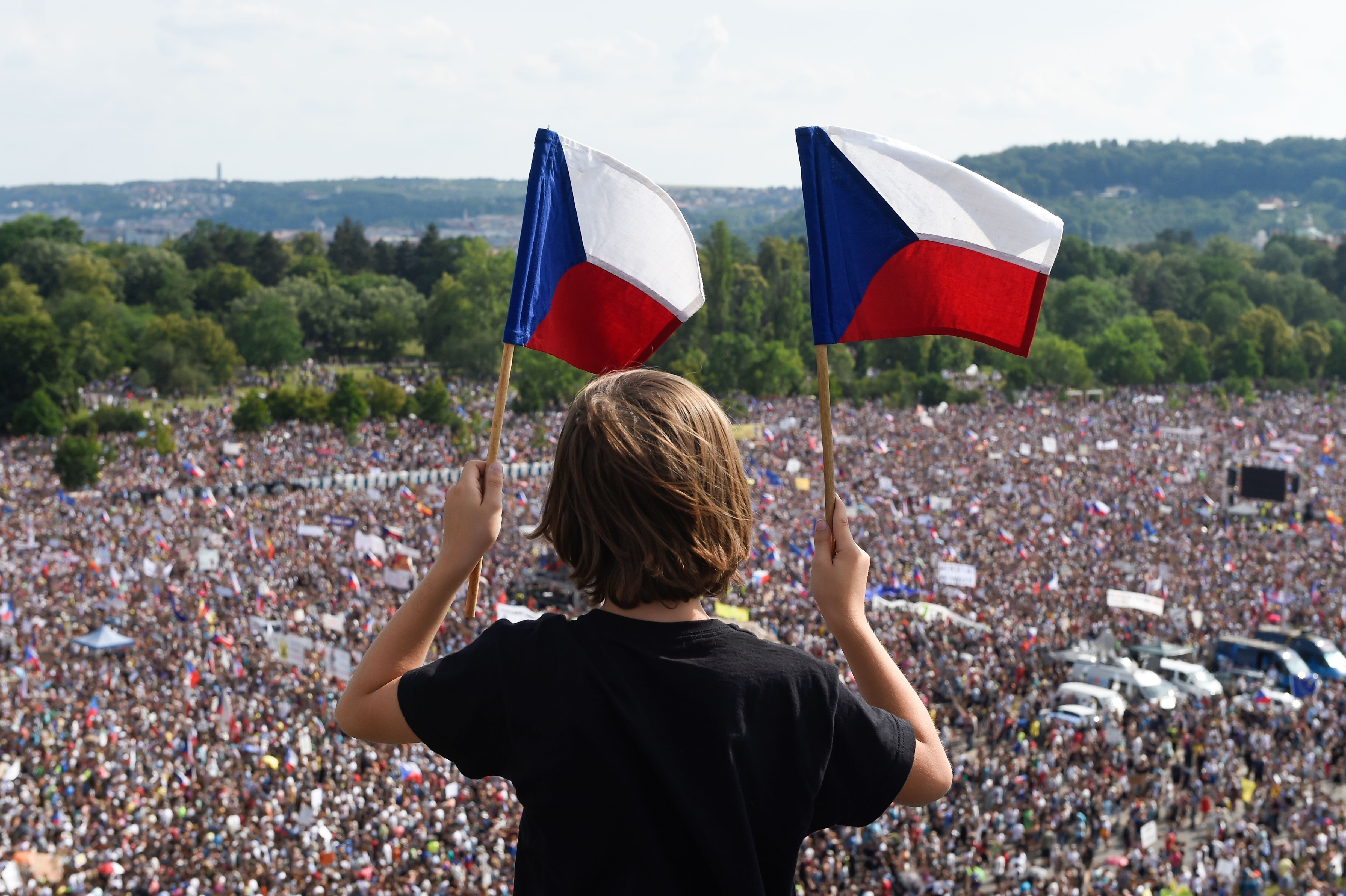 A boy holds Czech National flags during a rally demanding the resignation of Czech Prime Minister Andrej Babis on June 23, 2019 in Prague. 