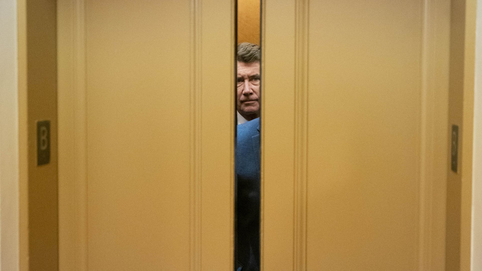 Sen. Bill Hagerty is seen between two closing Senate elevator doors.