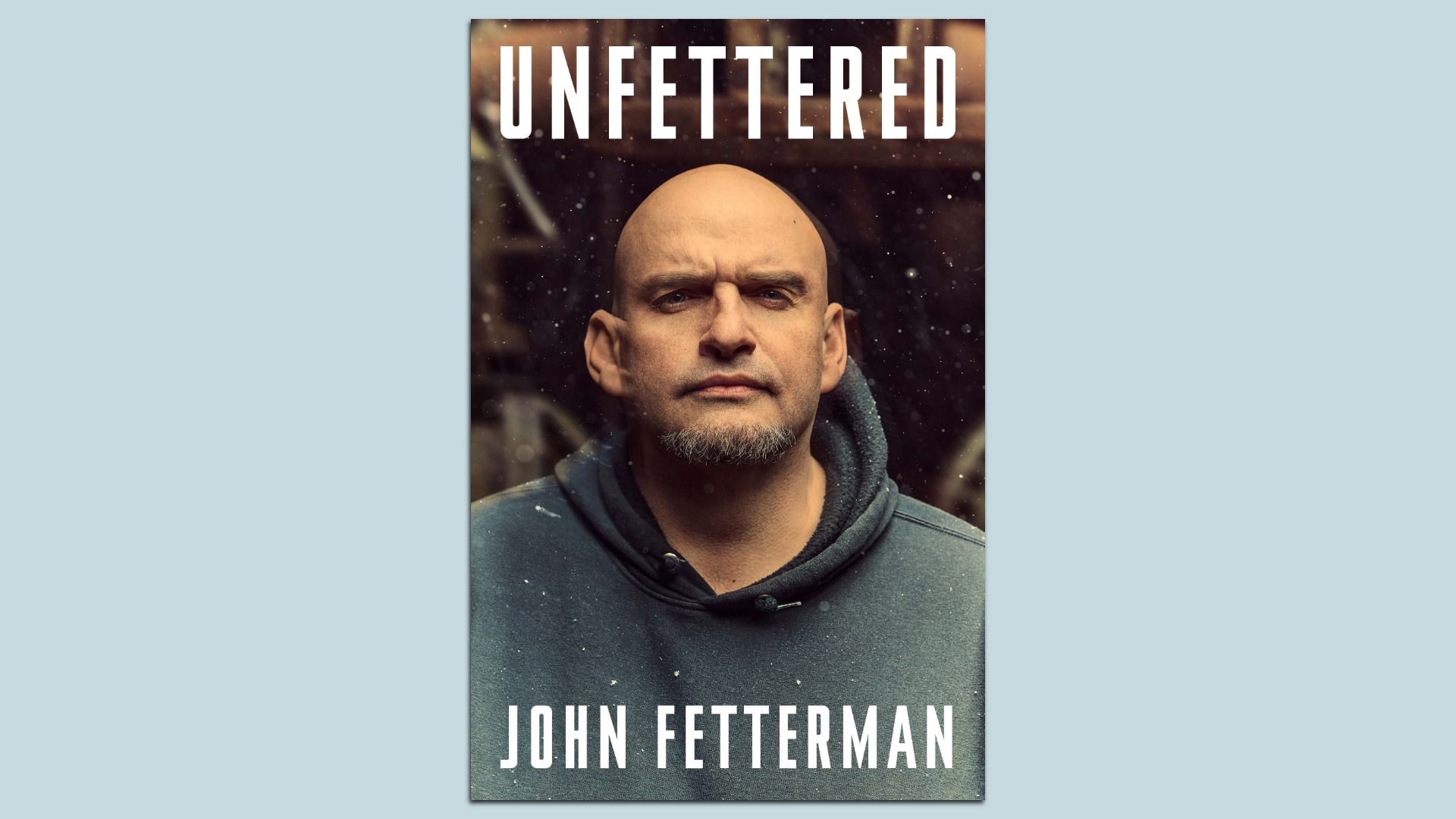 Book cover of "Unfettered" featuring Sen. John Fetterman wearing a dark hoodie against a blurred, dark background.