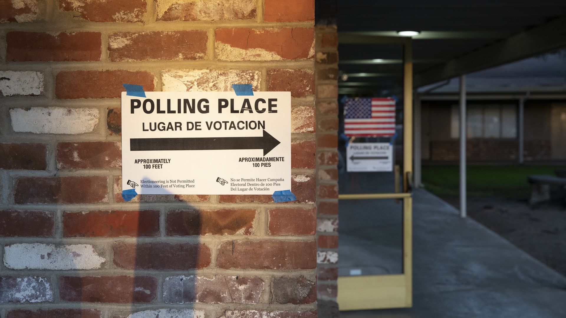A sigh for a polling place on a brick wall