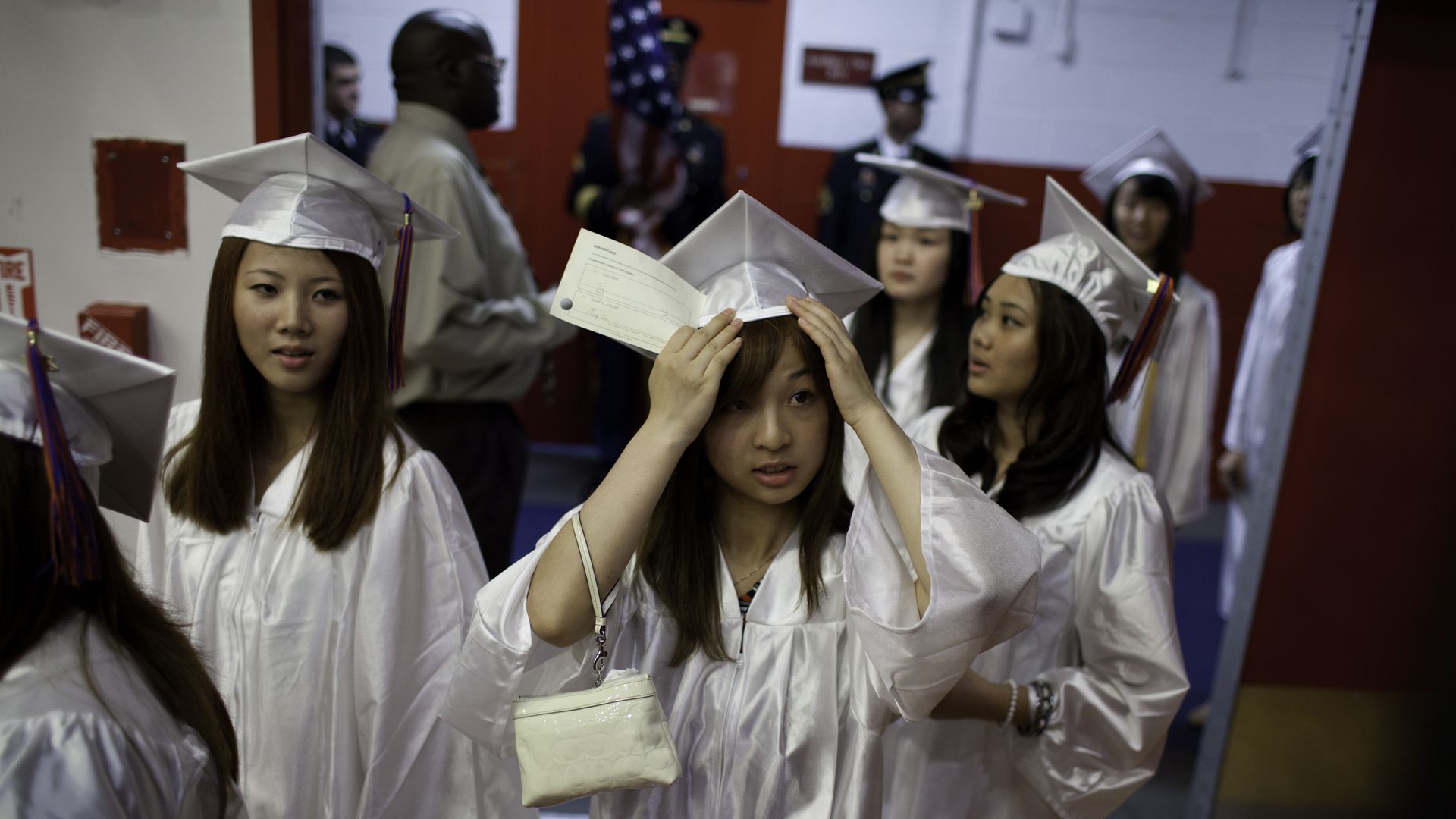 Bayside High School Asian American seniors walk to their seats for their graduation ceremony