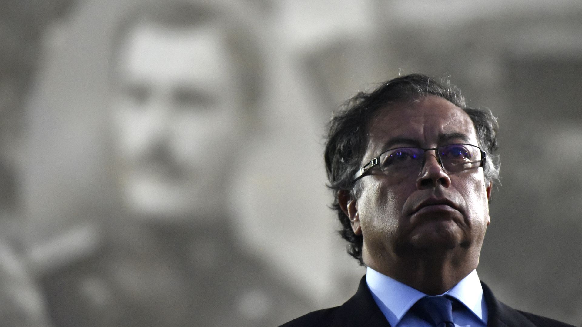 Colombian President Gustavo Petro stands with shadows behind him
