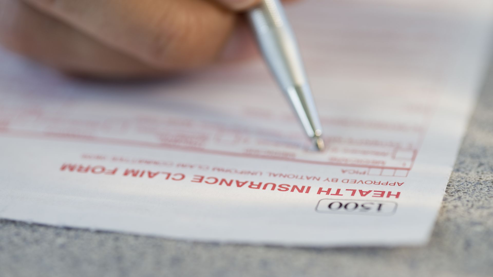 A person fills out a health insurance form.