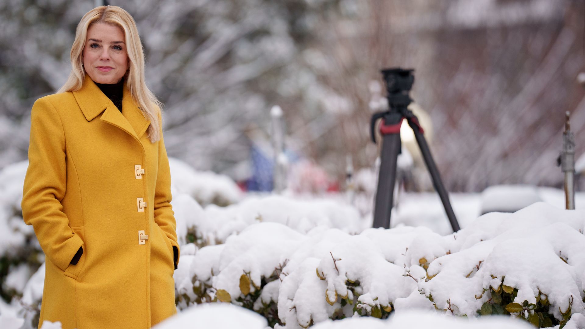 Woman in yellow coat with snow in backdrop