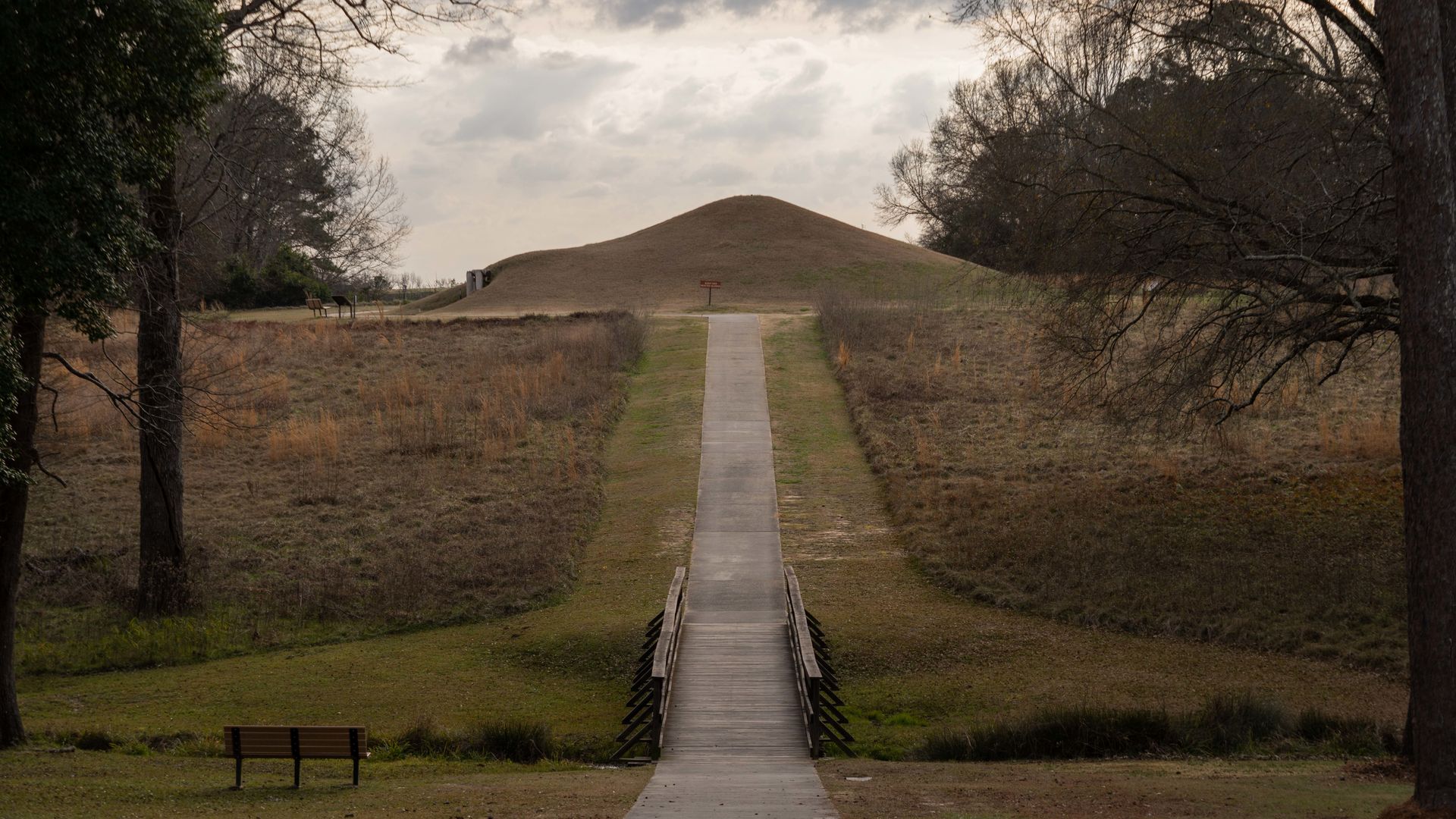 A photo of a path leading up a hill to a large mound
