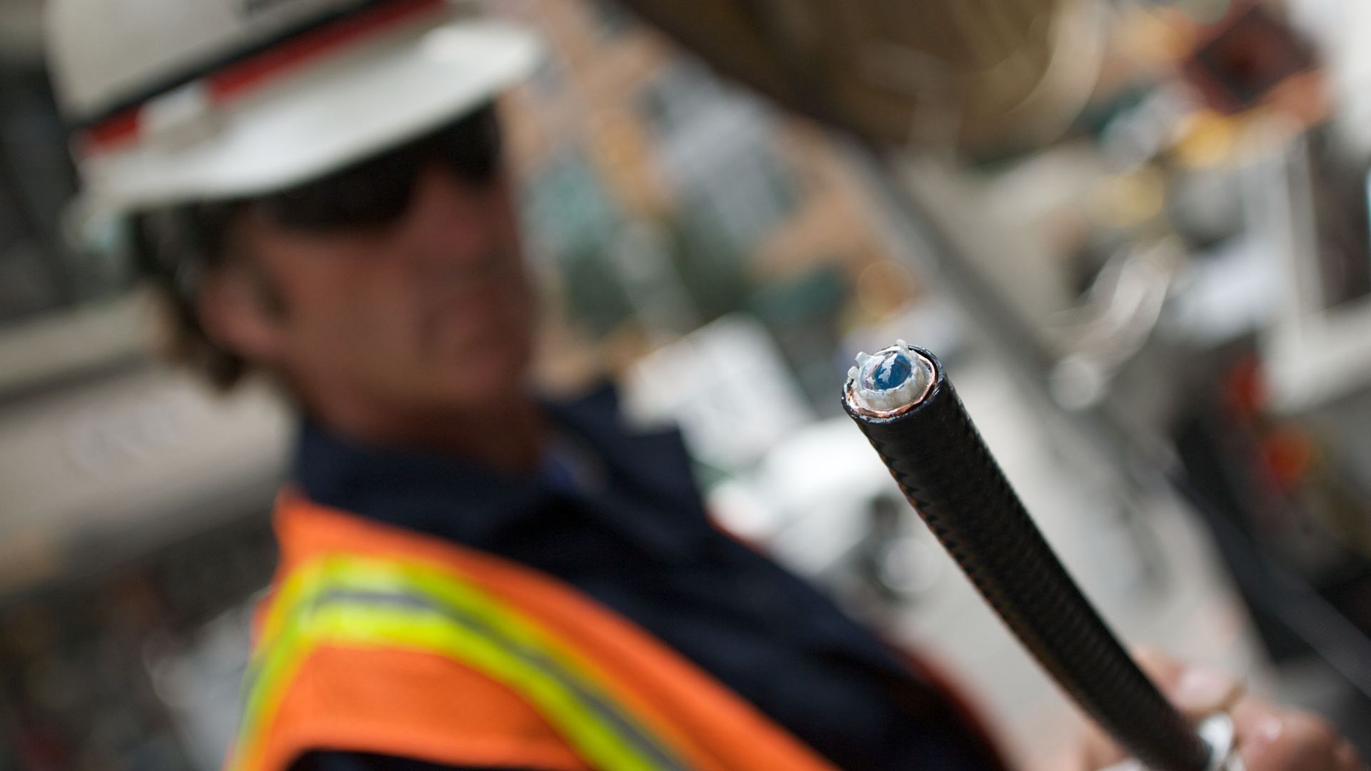 A man holding up a fiber-optic cable