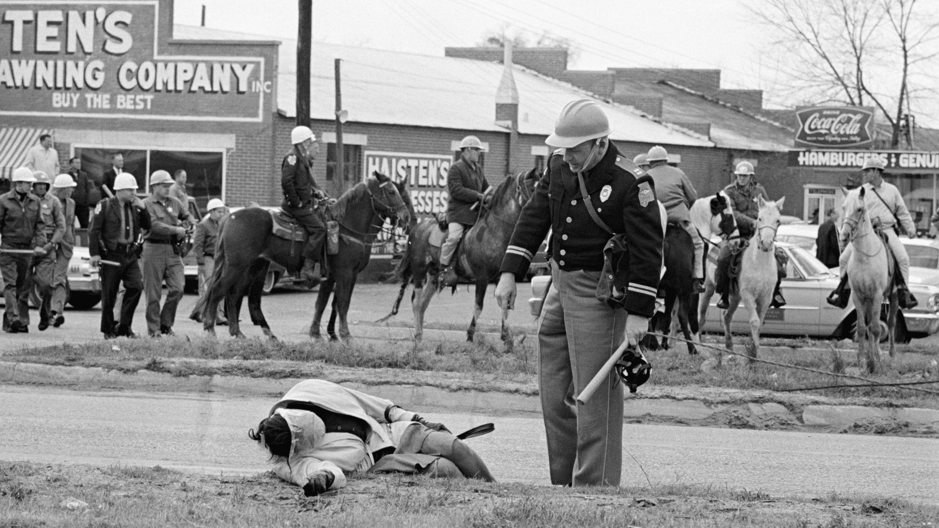 An Alabama officer accosts an unconscious woman as mounted police officers attack civil rights marchers in Selma, Alabama who were attempting to begin a 50 mile march to Montgomery to protest race discrimination in voter registration on March 7, 1965.