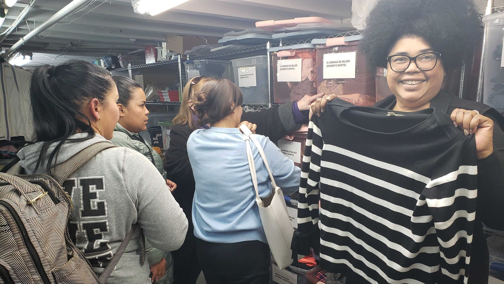 Photo of a woman holding up a shirt at a store