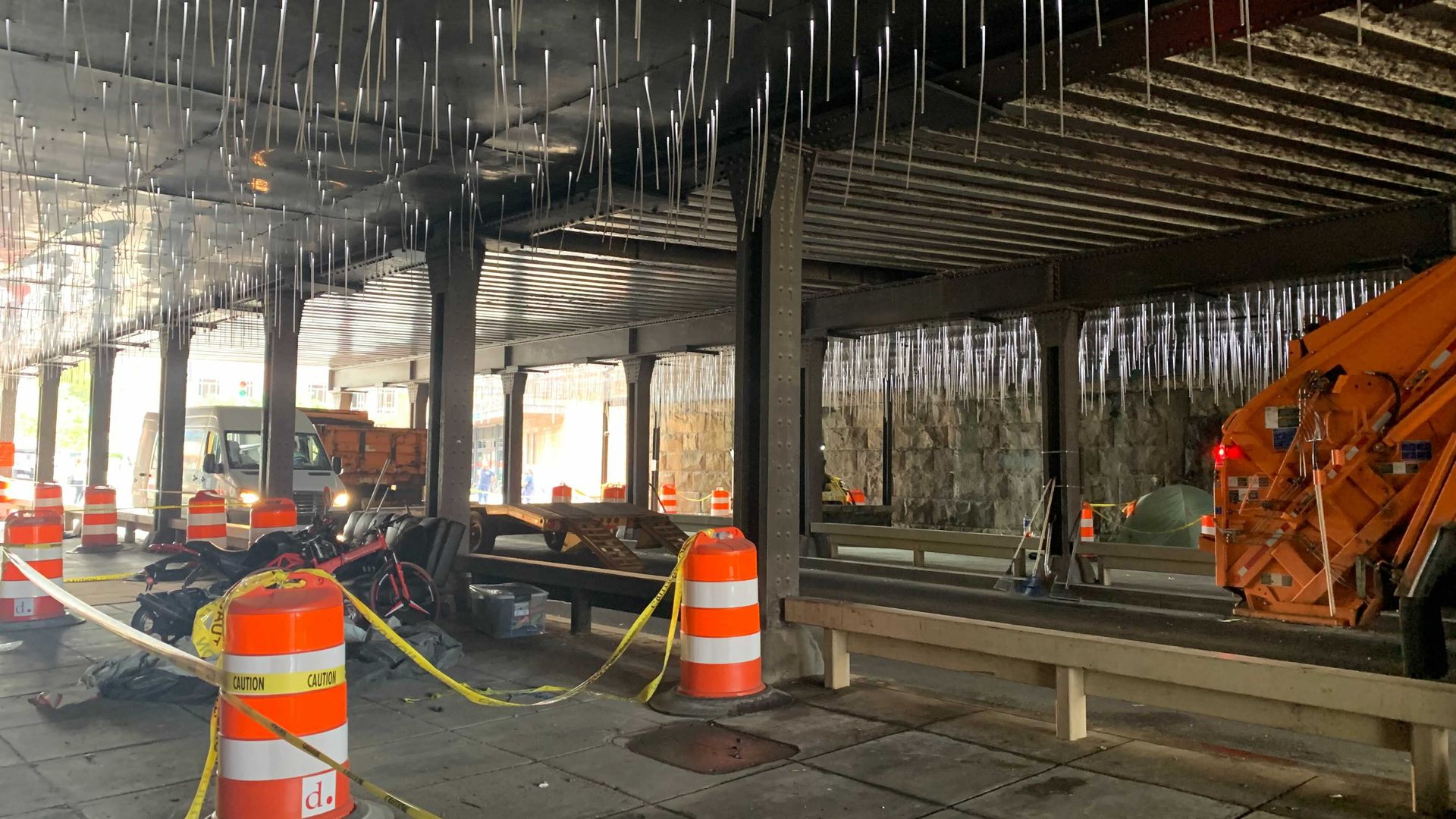 A homeless encampment under a underpass is cleared.