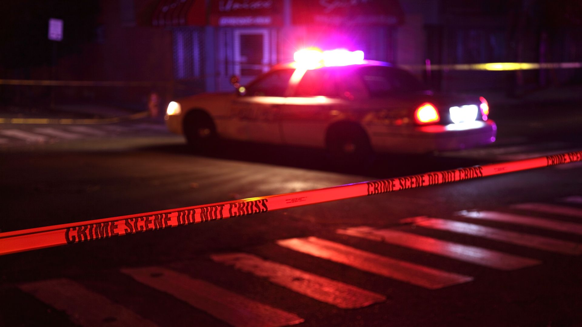 Police car and crime scene tape on a city street