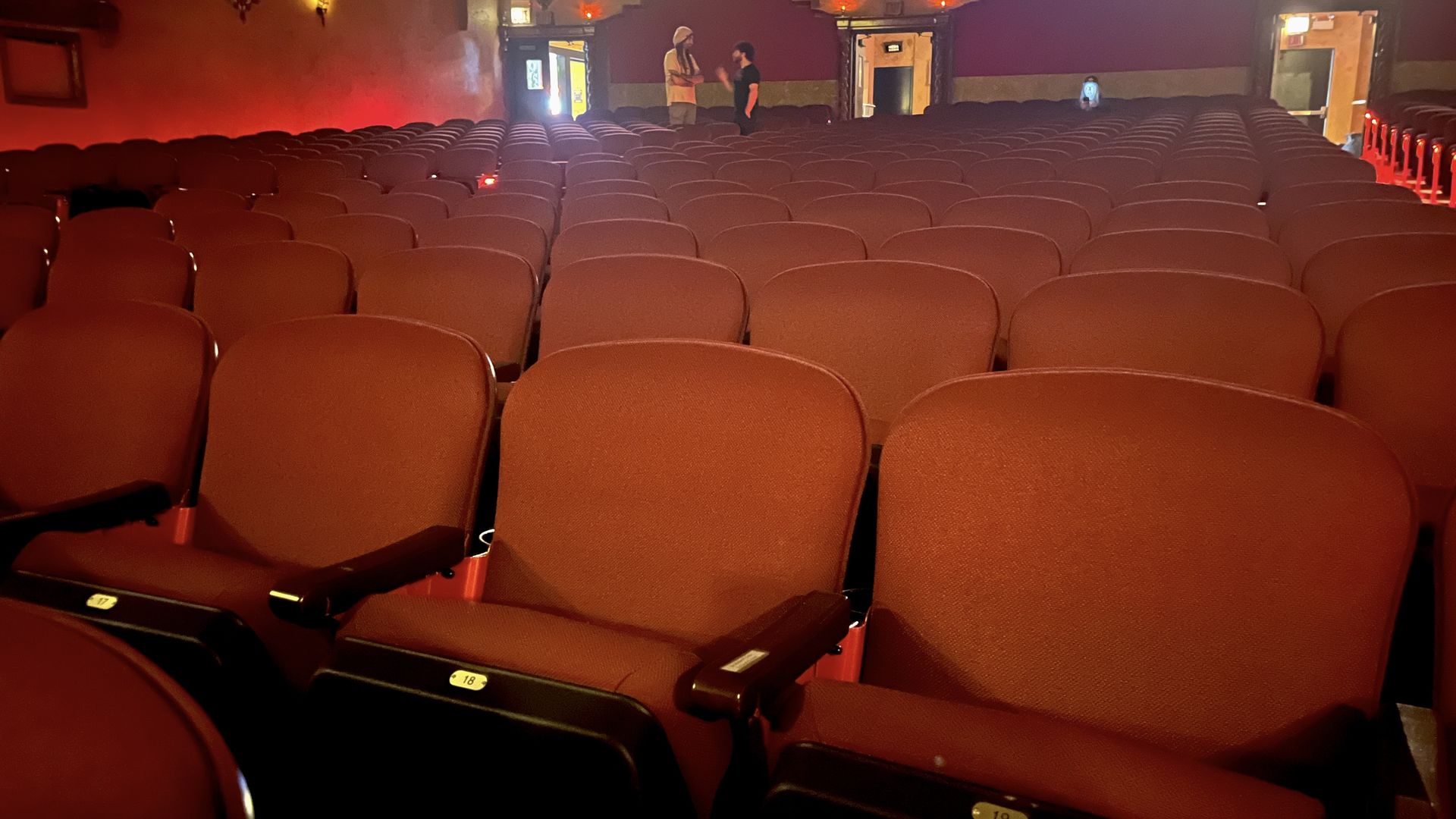 Empty red seats in a movie theater.
