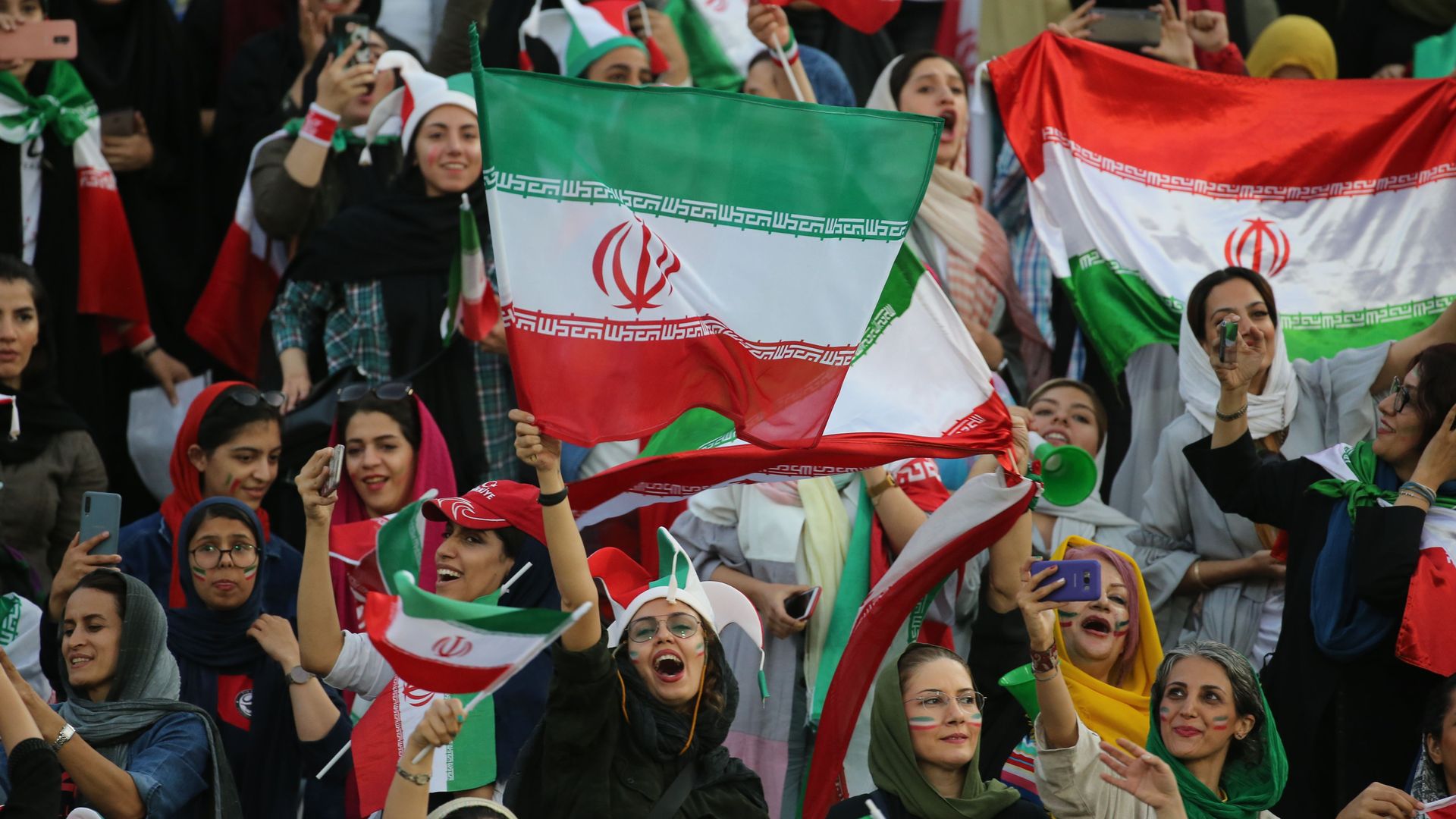 Iranian women cheering at a soccer game