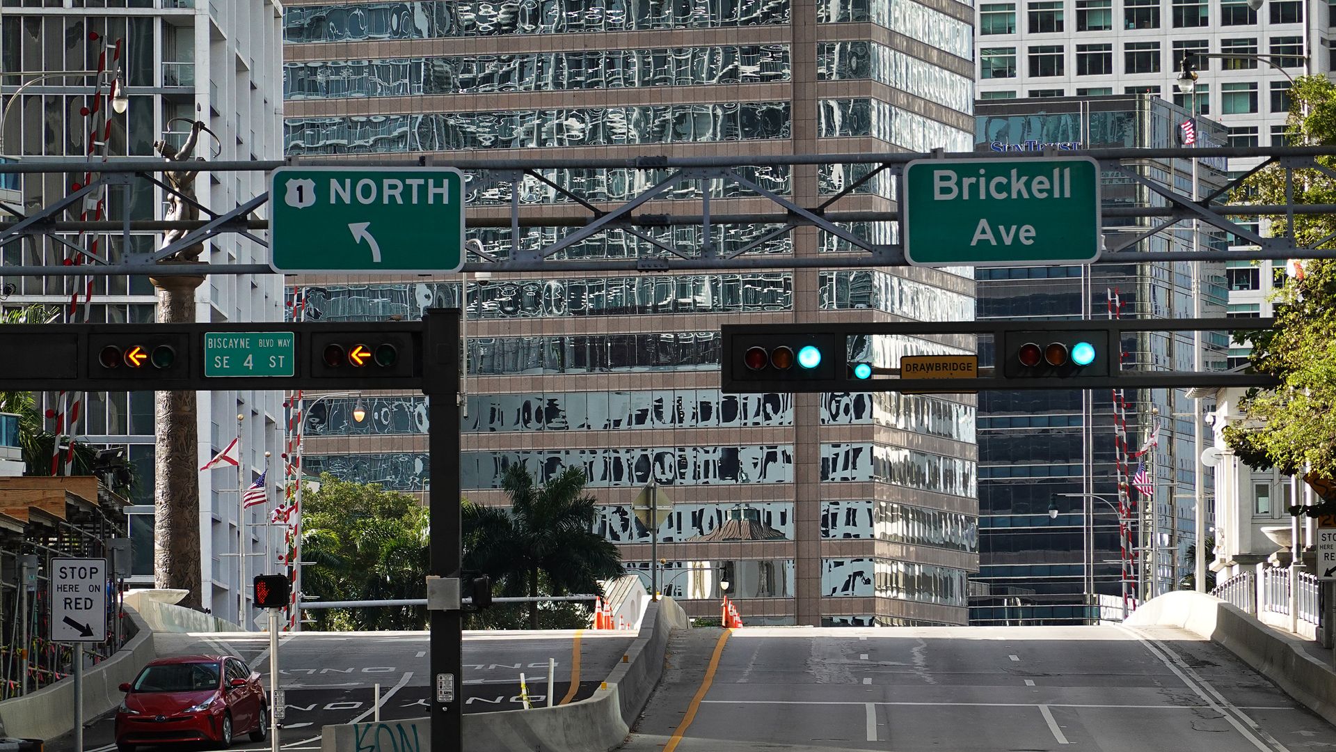 Picture of a street at an intersection with green lights.