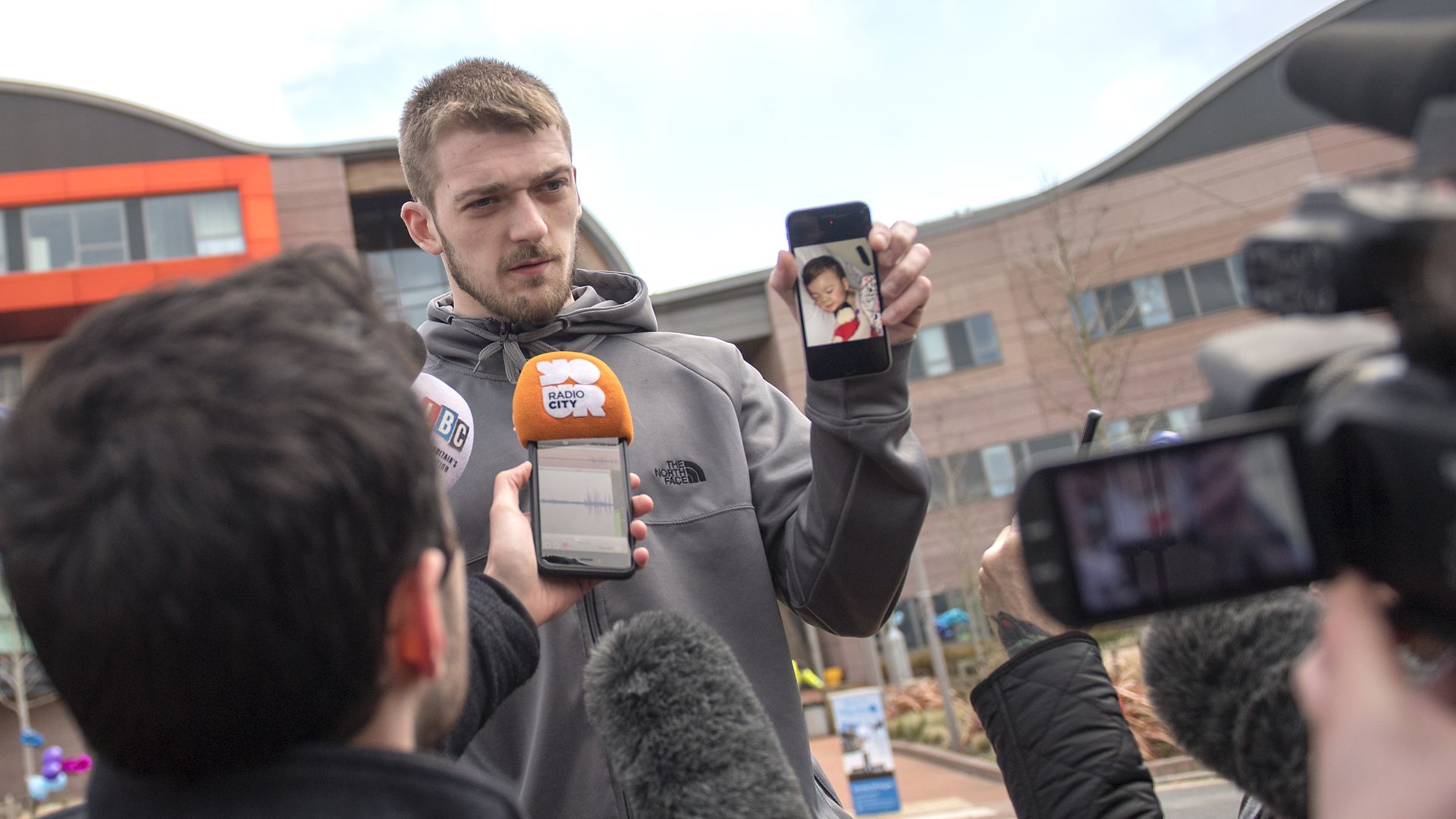 Tom Evans, Father of Alfie Evans, holds a photograph of his son as he speaks to media outside Alder Hey Children's Hospital.