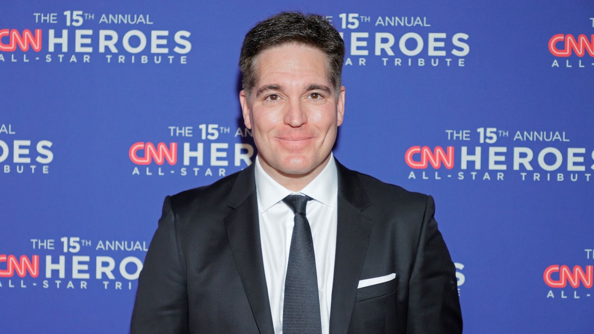WarnerMedia CEO Jason Kilar standing by himself in front of a CNN Heroes step and repeat.