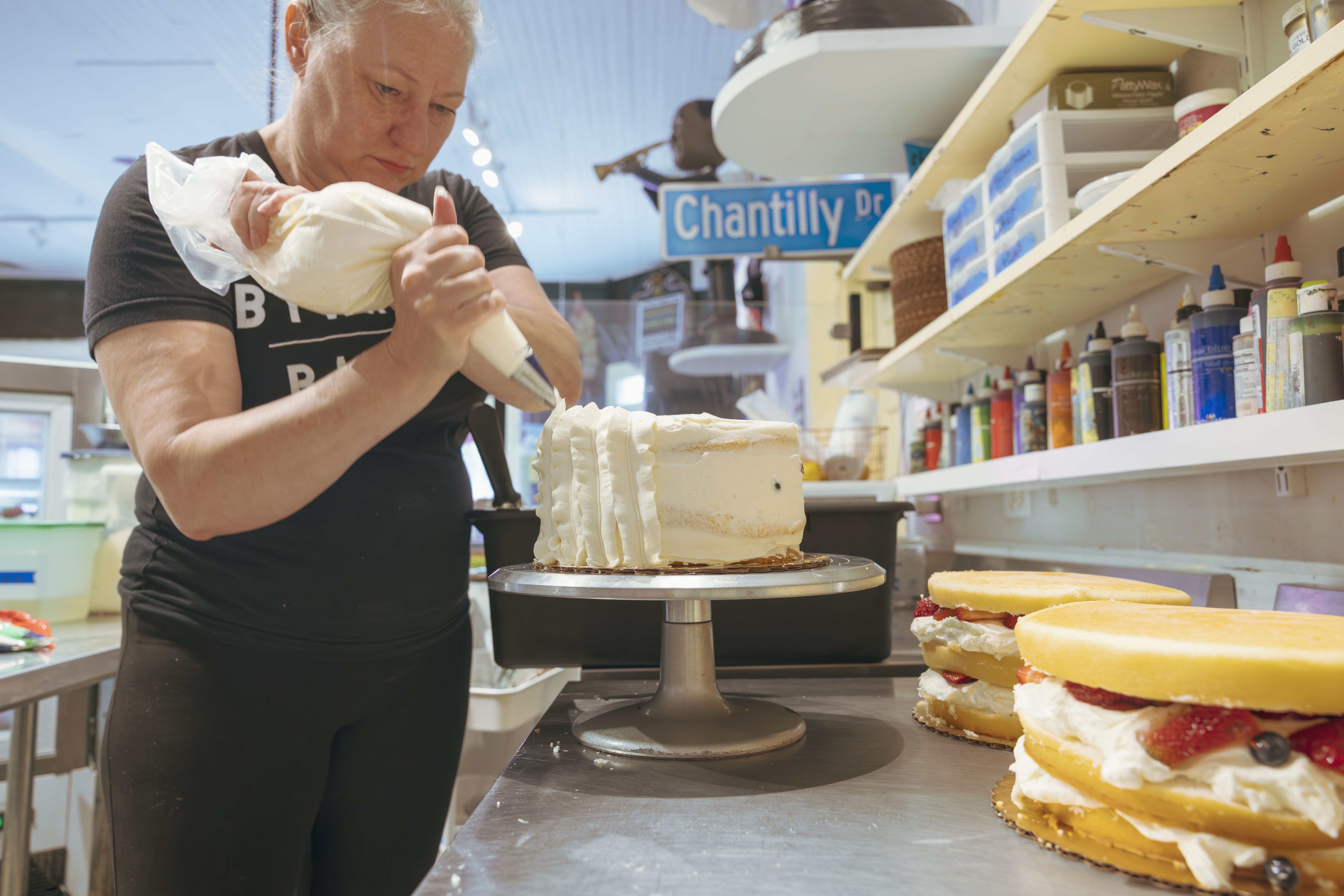 Photo shows Chaya Conrad icing a cake.