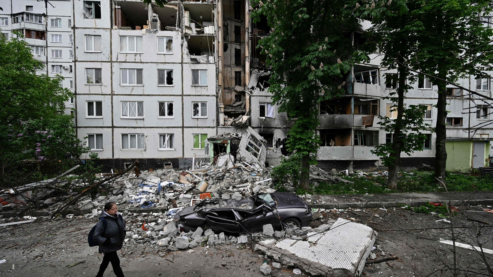 A woman walks past a heavily damaged residential building in the Saltivka district, northern Kharkiv on May 29, 2022, amid Russian invasion of Ukraine.
