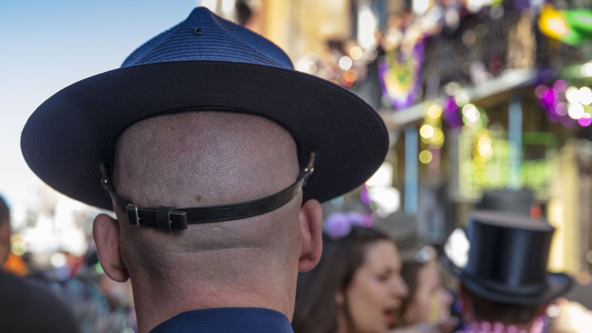 Photo shows a man with a Louisiana State Police hat on in the French Quarter