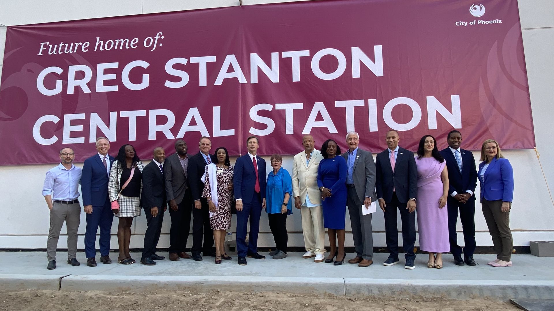 Greg Stanton poses with more than a dozen others under banner that reads Future home of Greg Stanton Central Station.