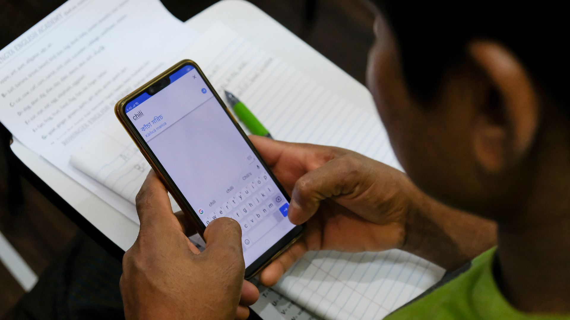 In this image, a student holds a smartphone that is using Google translate