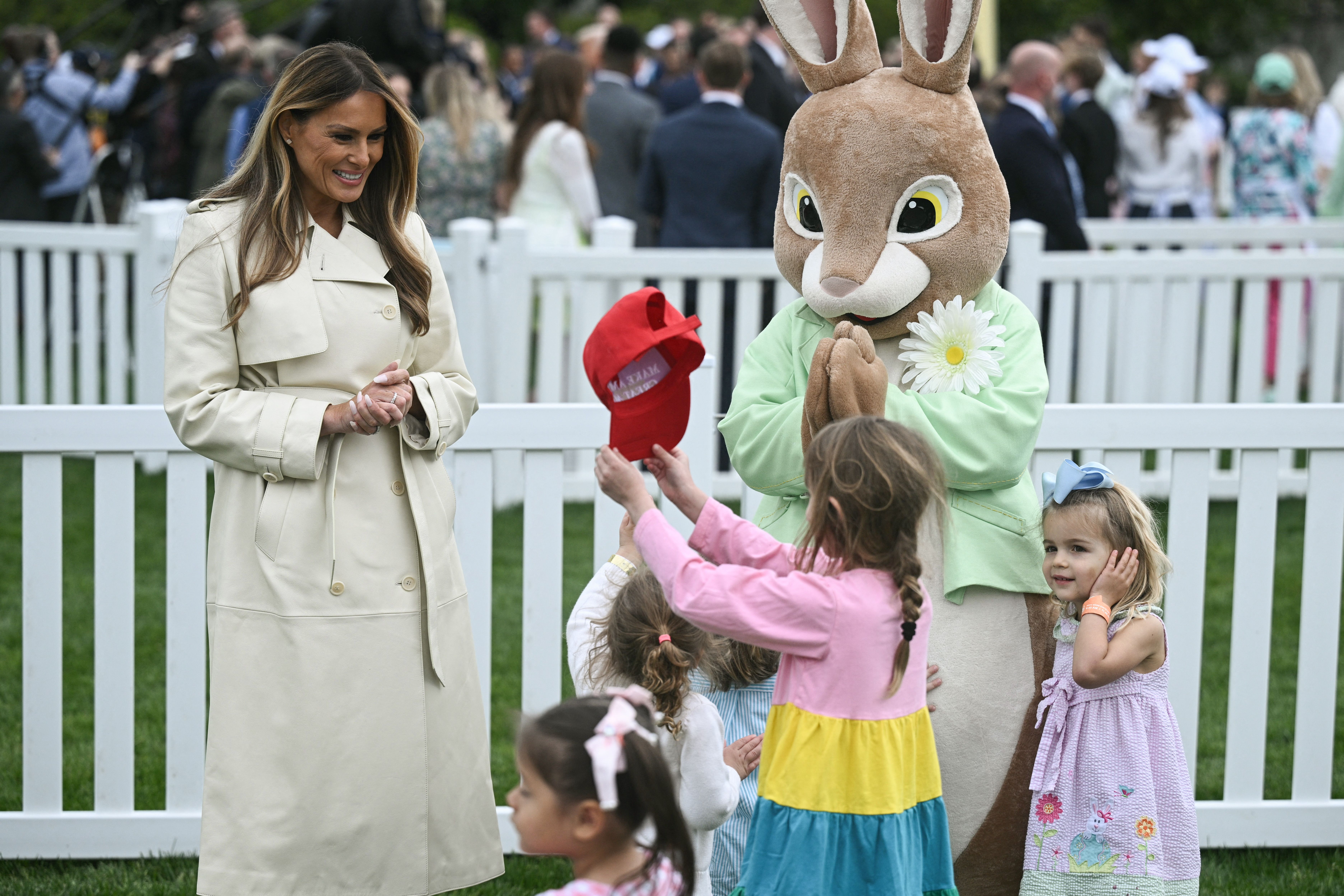 A child shows Melania Trump a MAGA hat.
