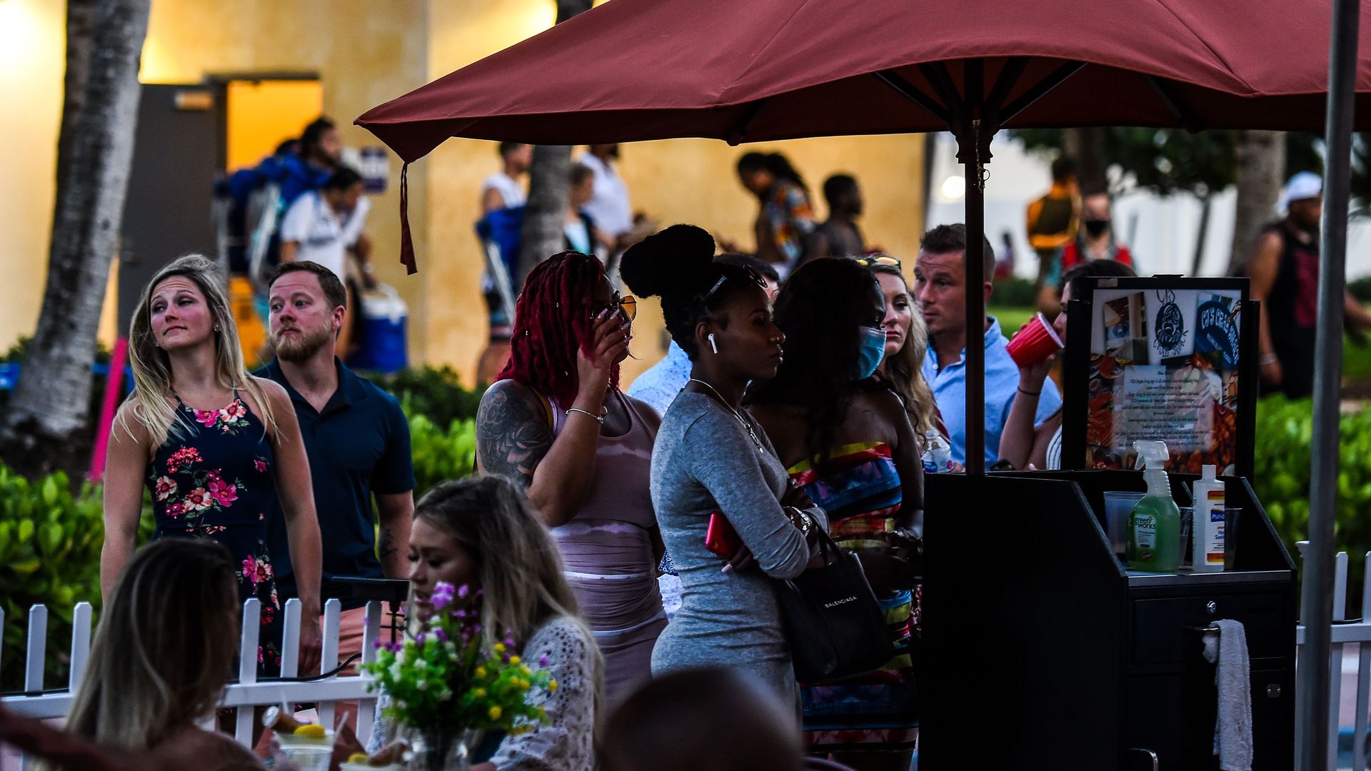 People stand under an umbrella outside