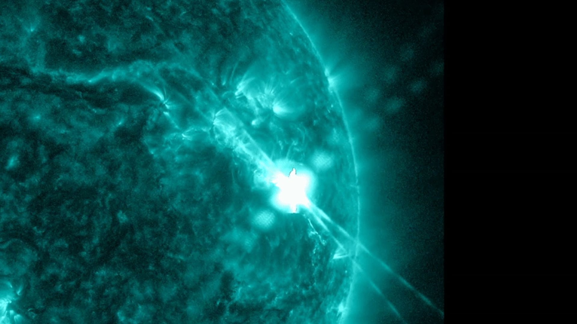 NASA’s Solar Dynamics Observatory captured this image of a solar flare – as seen in the bright flash in the upper right – on Dec. 14. The image shows a subset of extreme ultraviolet light that highlights the extremely hot material in flares, and which is colorized in teal. 