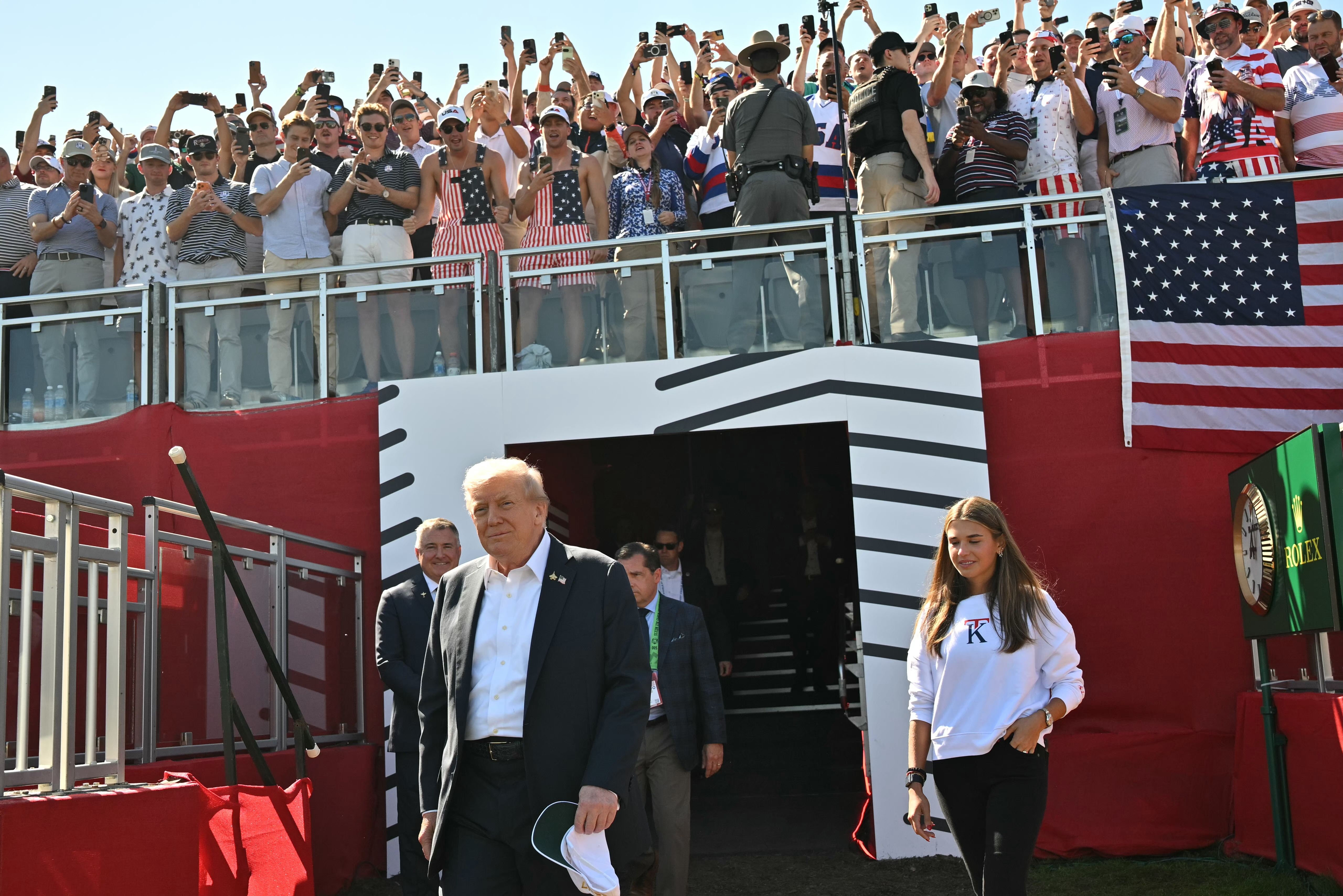 FARMINGDALE, NEW YORK - SEPTEMBER 26: U.S. President Donald Trump, along with his granddaughter Kai Madison Trump, attends the 2025 Ryder Cup at Black Course at Bethpage State Park Golf Course on September 26, 2025 in Farmingdale, New York. In his second term, Trump has attended several major sporti
