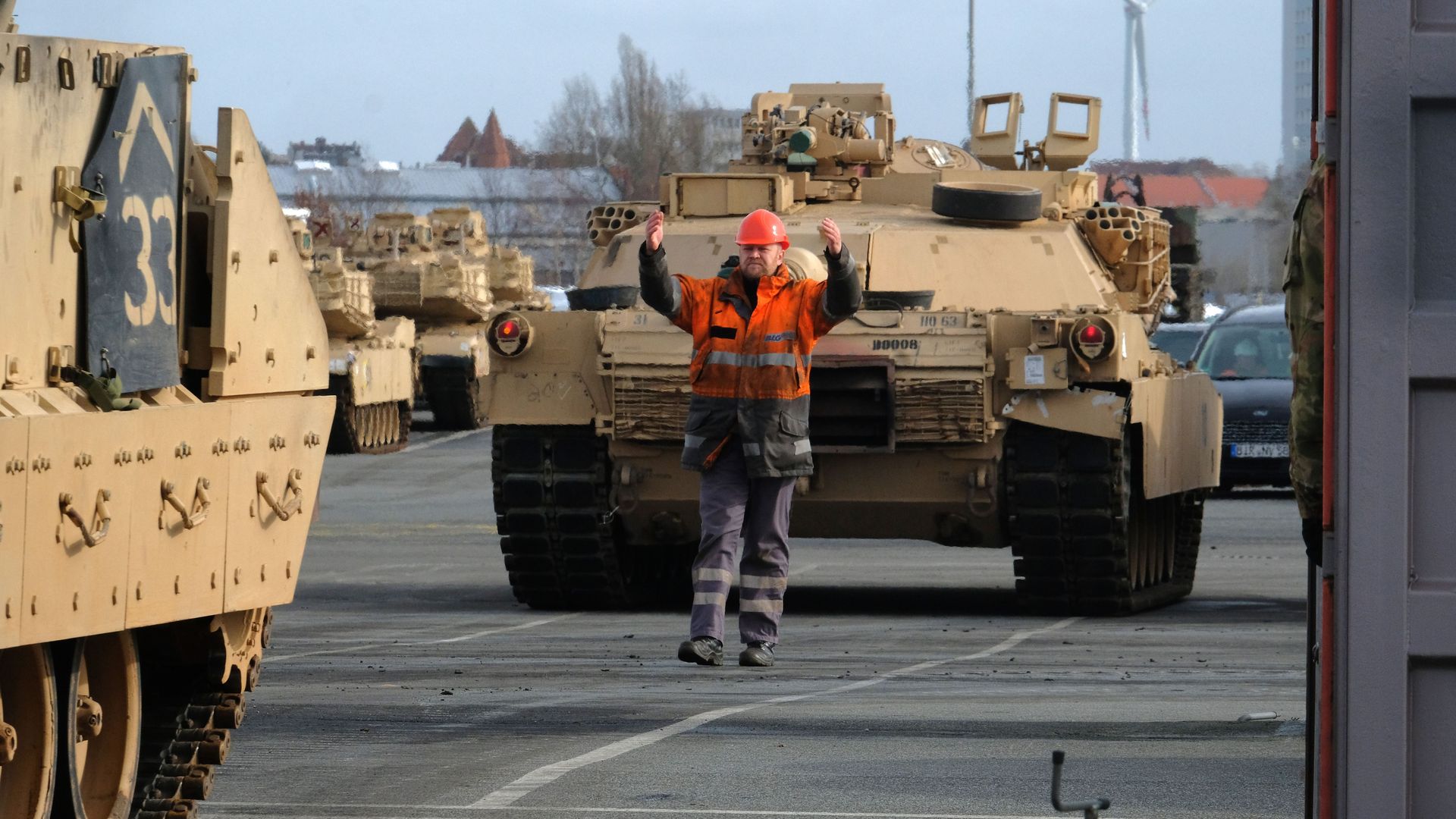 Two tanks drive down a concrete road