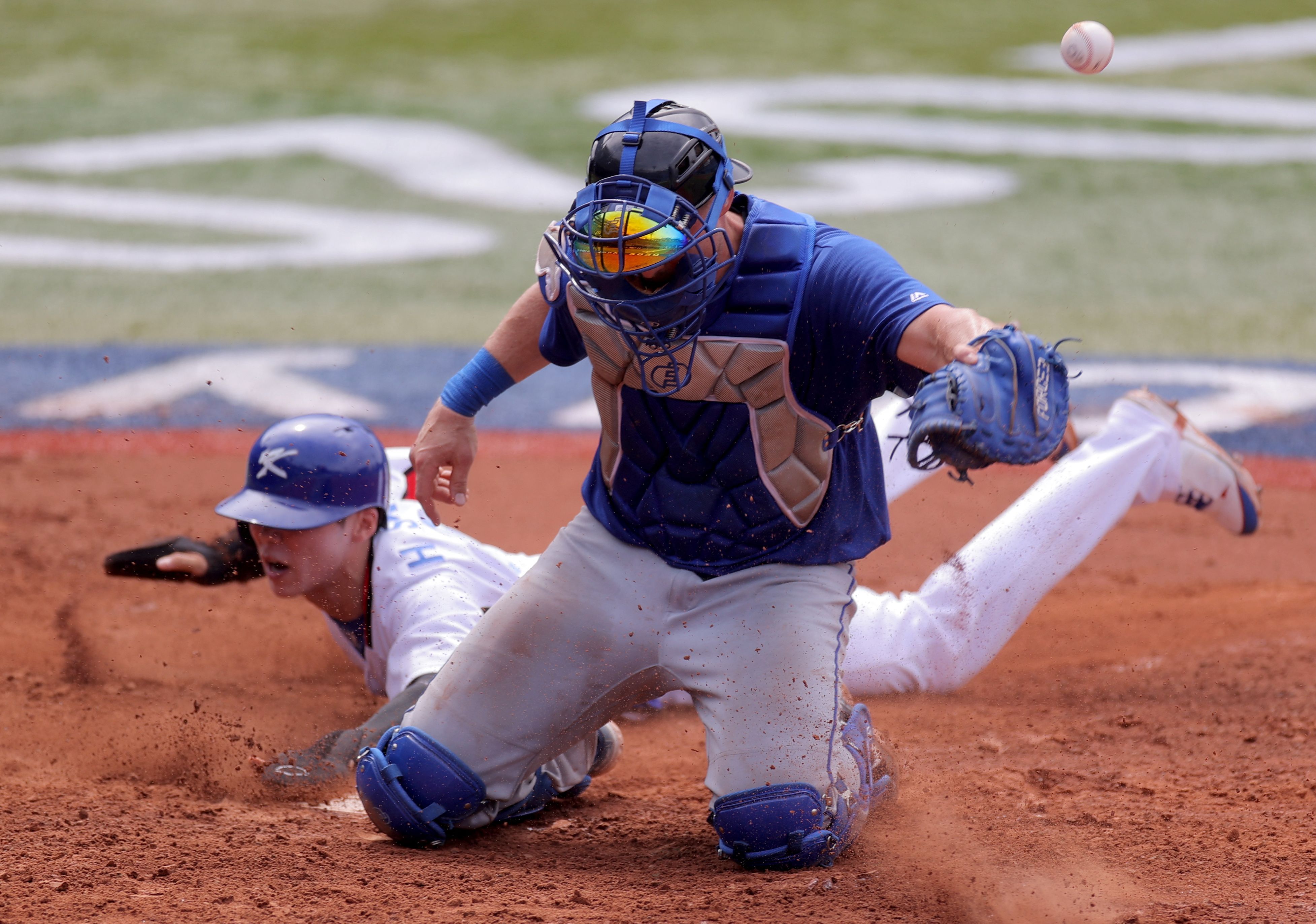  Israel's catcher Ryan Lavarnway (front) fails to catch the ball while South Korea's Kim Hyeseong (rear) at the Tokyo Olympics Aug. 2