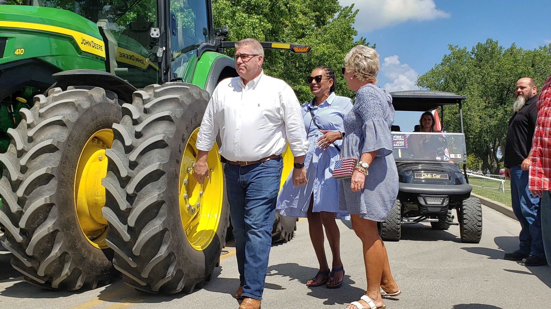Photo of a man walking past a tractor. 