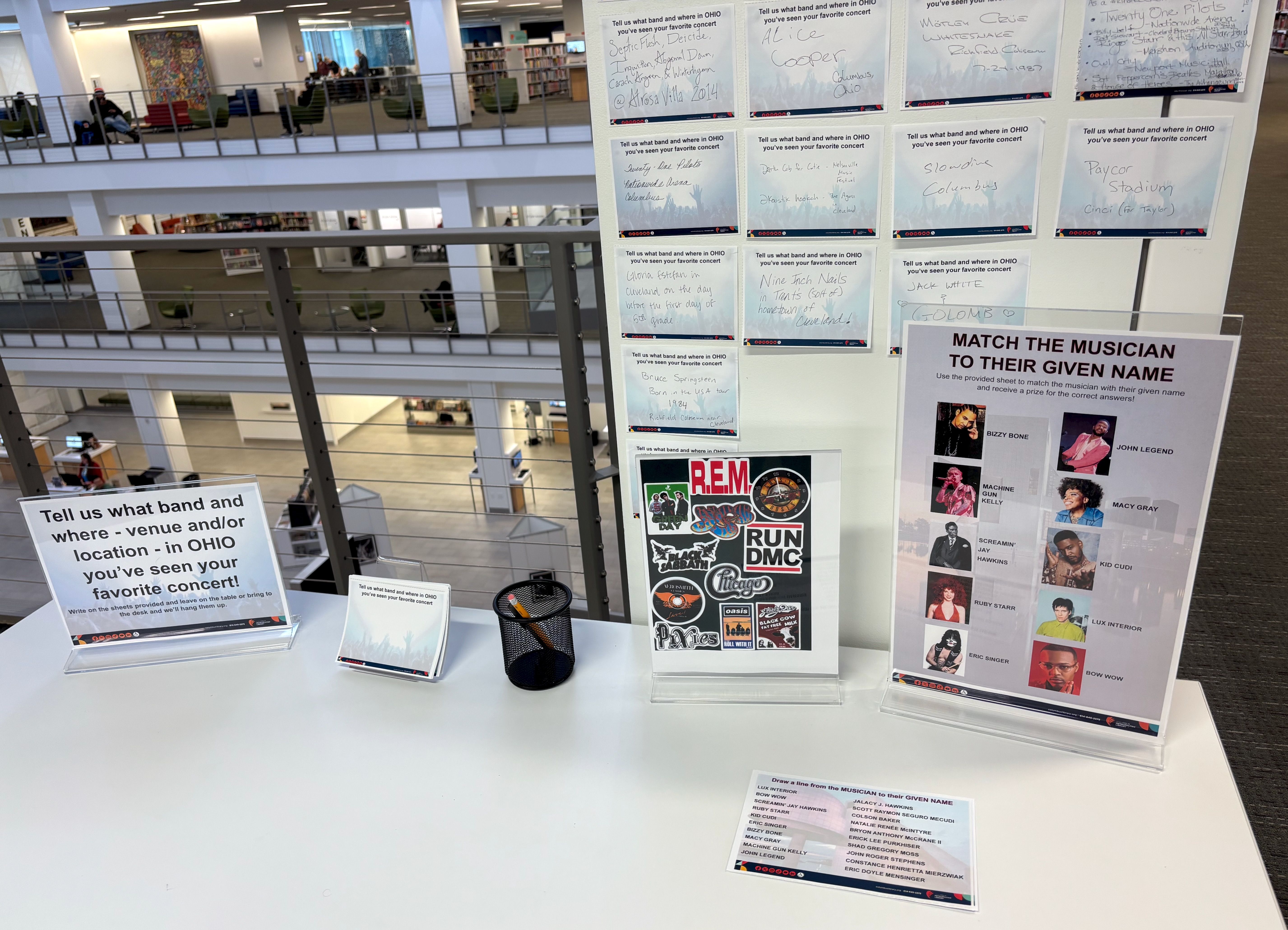 A table with a sign that reads "Tell us what band and where - venue and/or location - in Ohio you've seen your favorite concert!" plus a matching game involving rockstars and their stage names