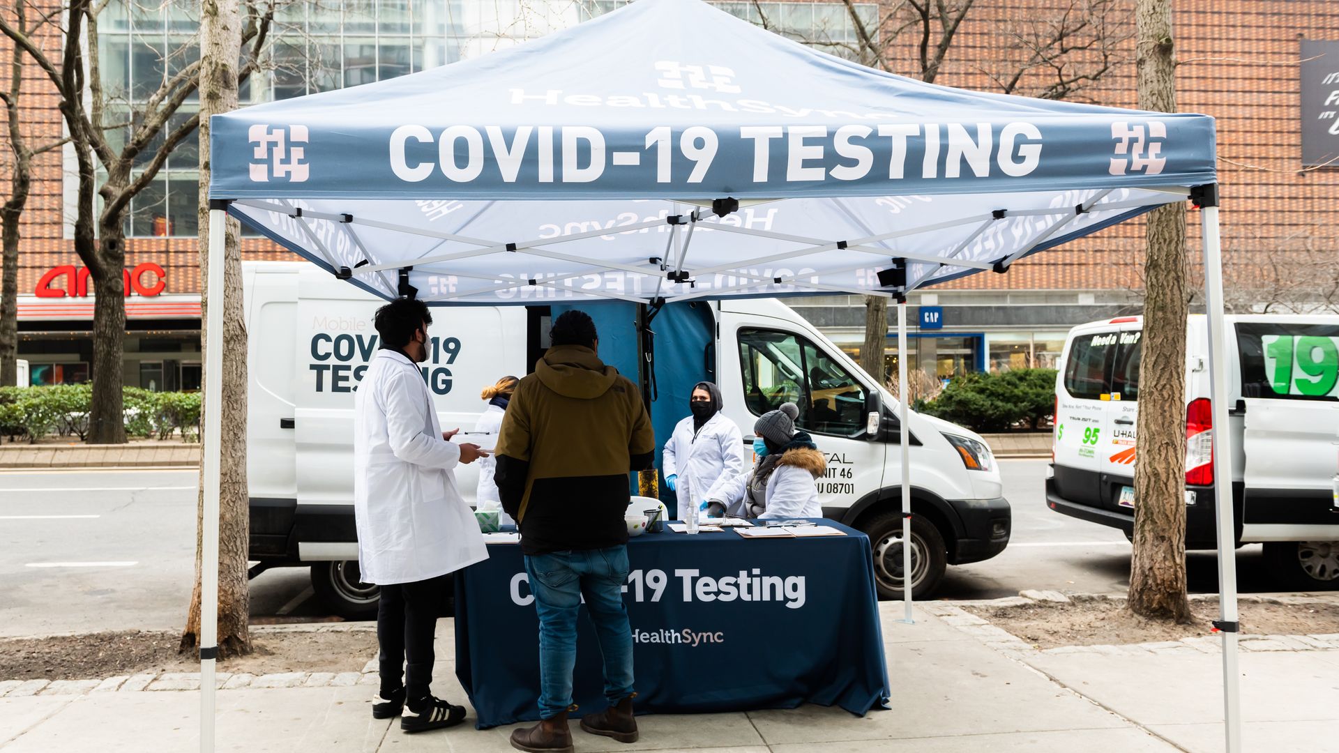 Photo of a COVID testing station with people around it