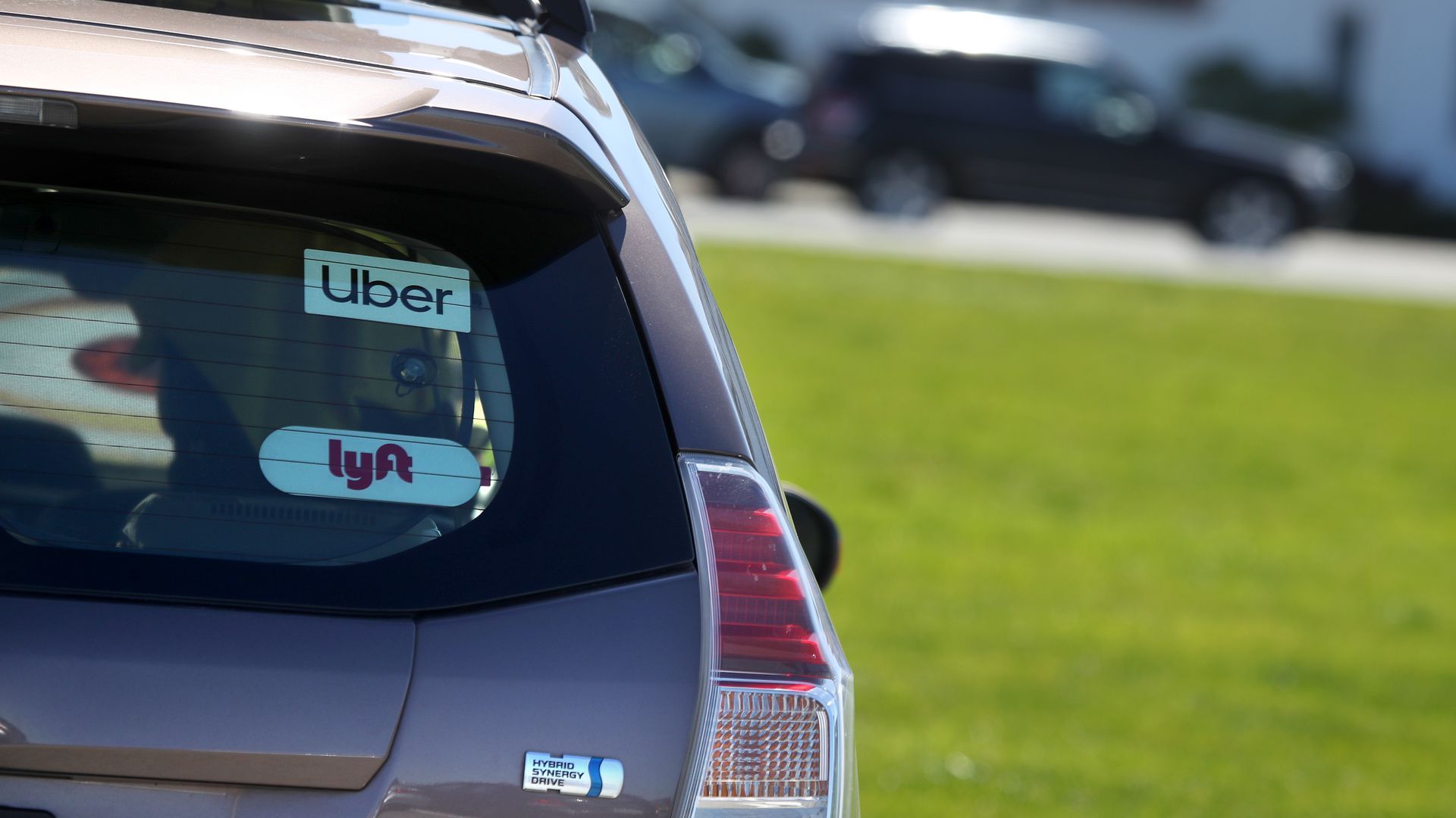 A car with Uber and Lyft stickers in the rear window