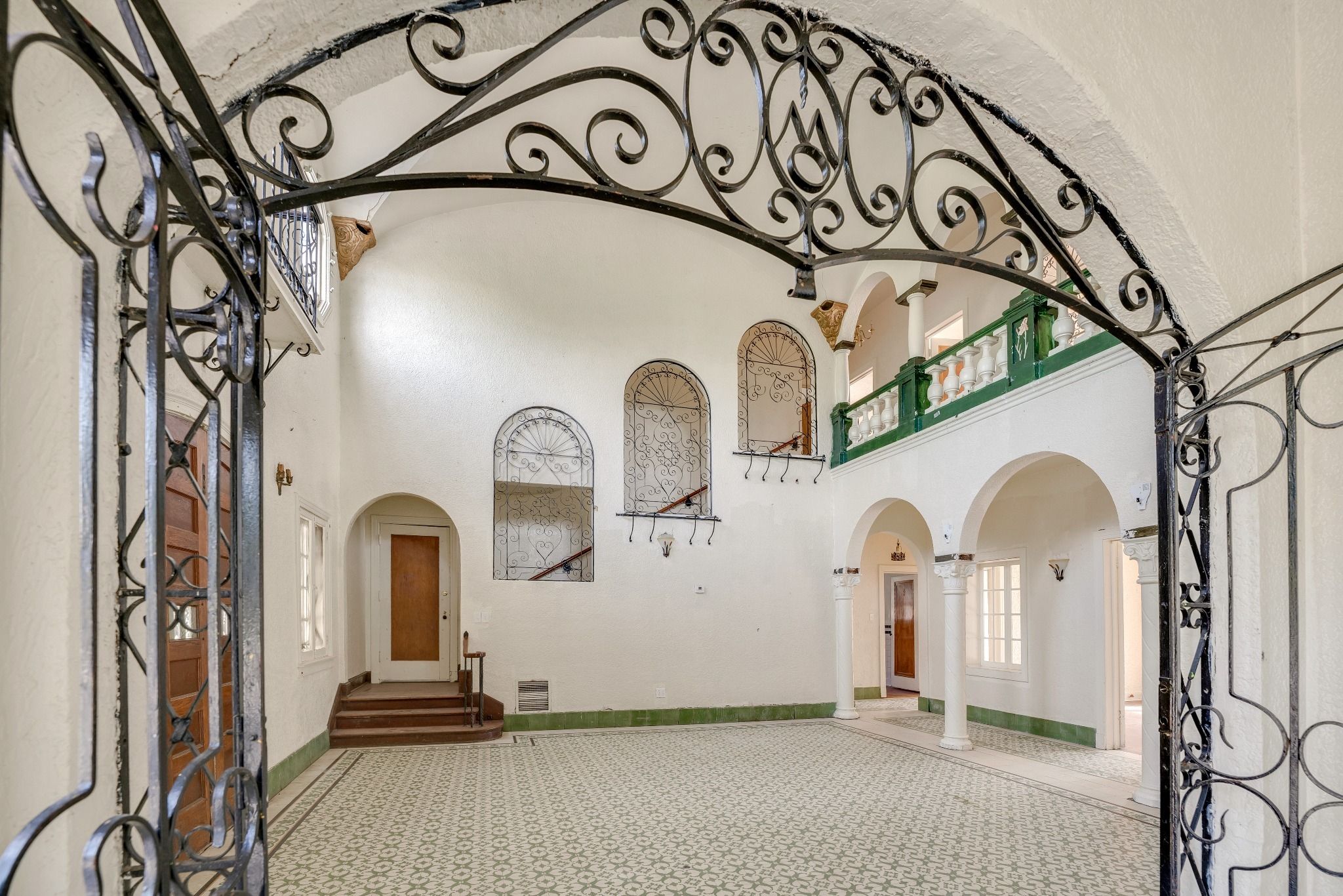 An iron-looking archway in a home with tall ceilings.