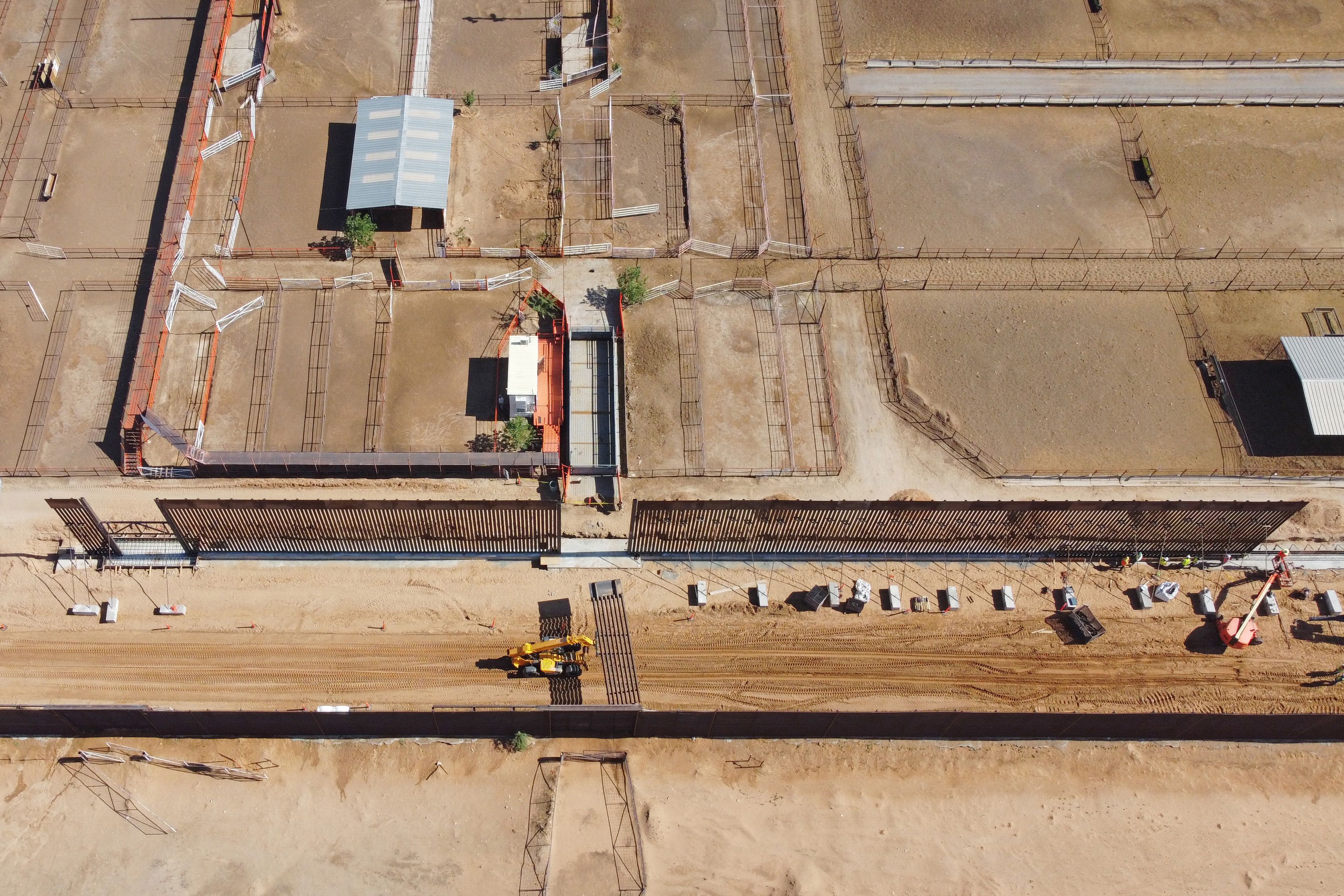 TOPSHOT - An aerial view of U.S. workers erect a new phase of the 7-mile border wall between Santa Teresa, New Mexico, and Ciudad Juarez, Chihuahua, Mexico on July 16, 2025. (Photo by AFP) (Photo by STRINGER/AFP via Getty Images)