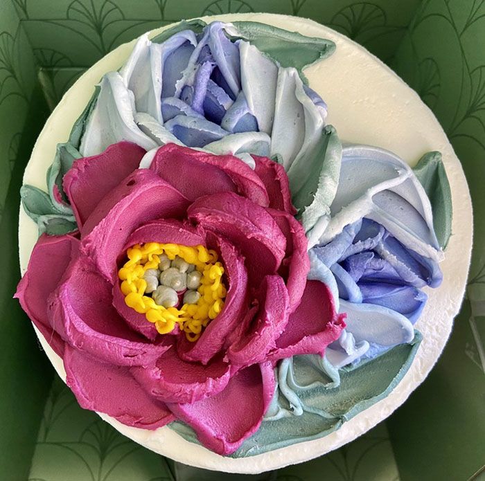 A peony and two roses top a signature chocolate cake at Miri Nadler Cake Design.