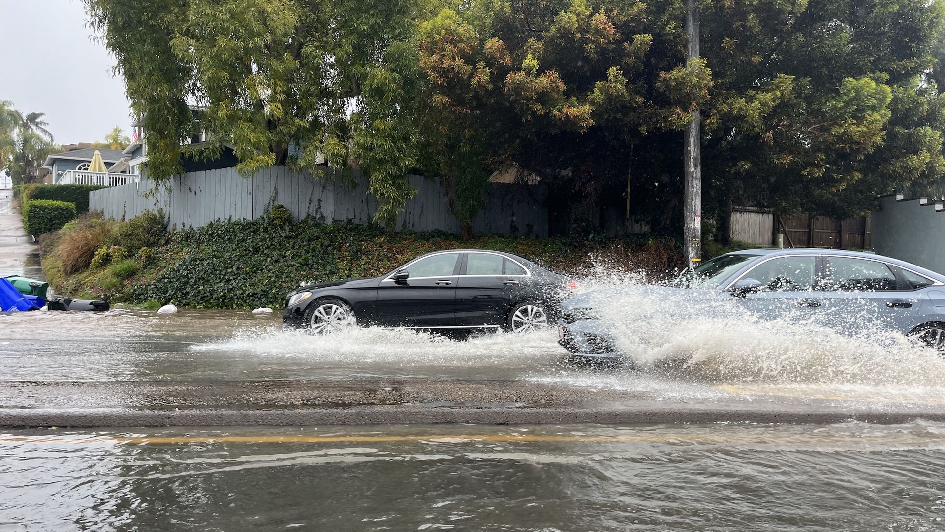 Cars drive through flooded streets in San Diego. 