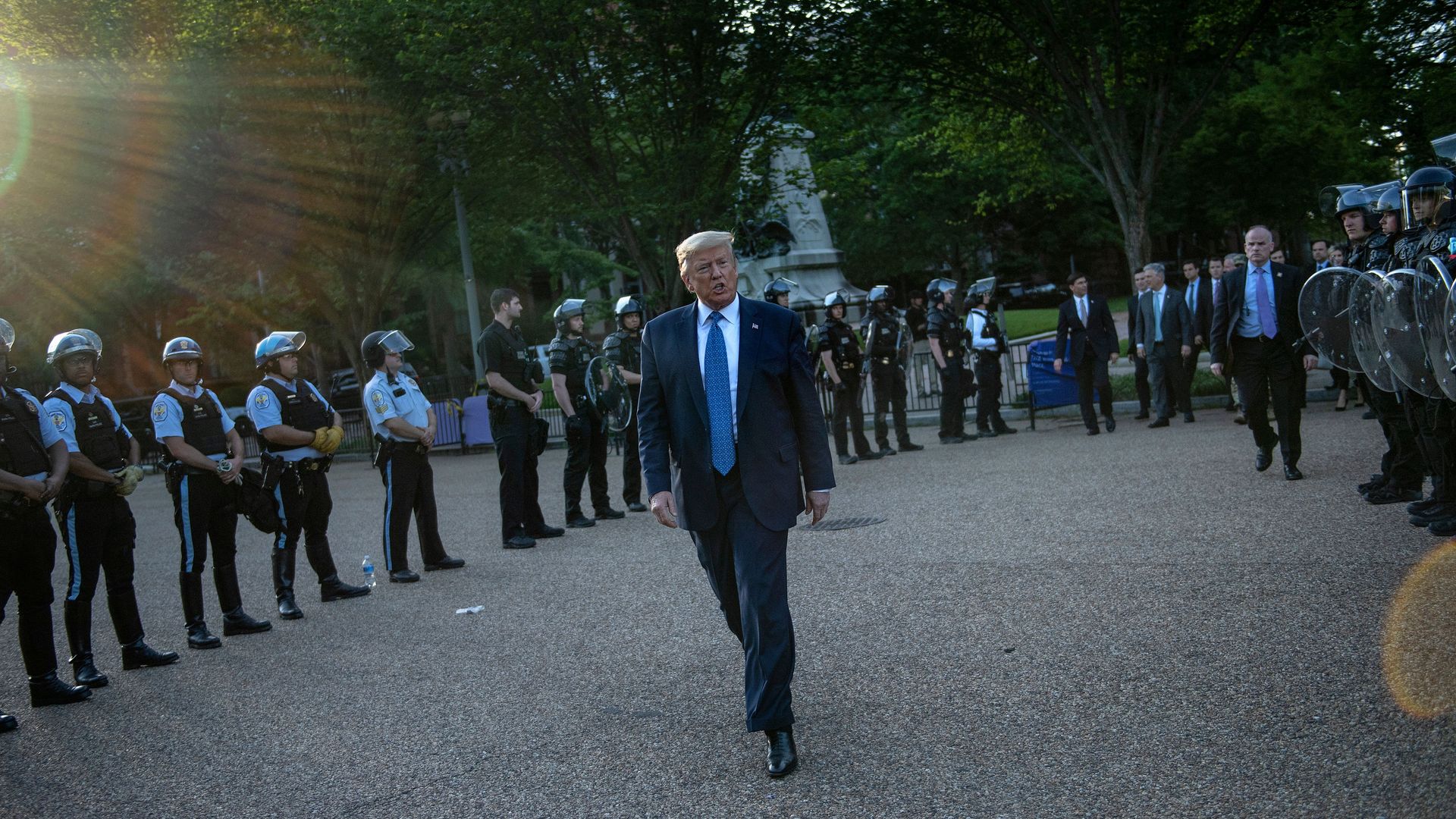 US President Donald Trump leaves the White House on foot to go to St John's Episcopal church across Lafayette Park as officers stand behind him