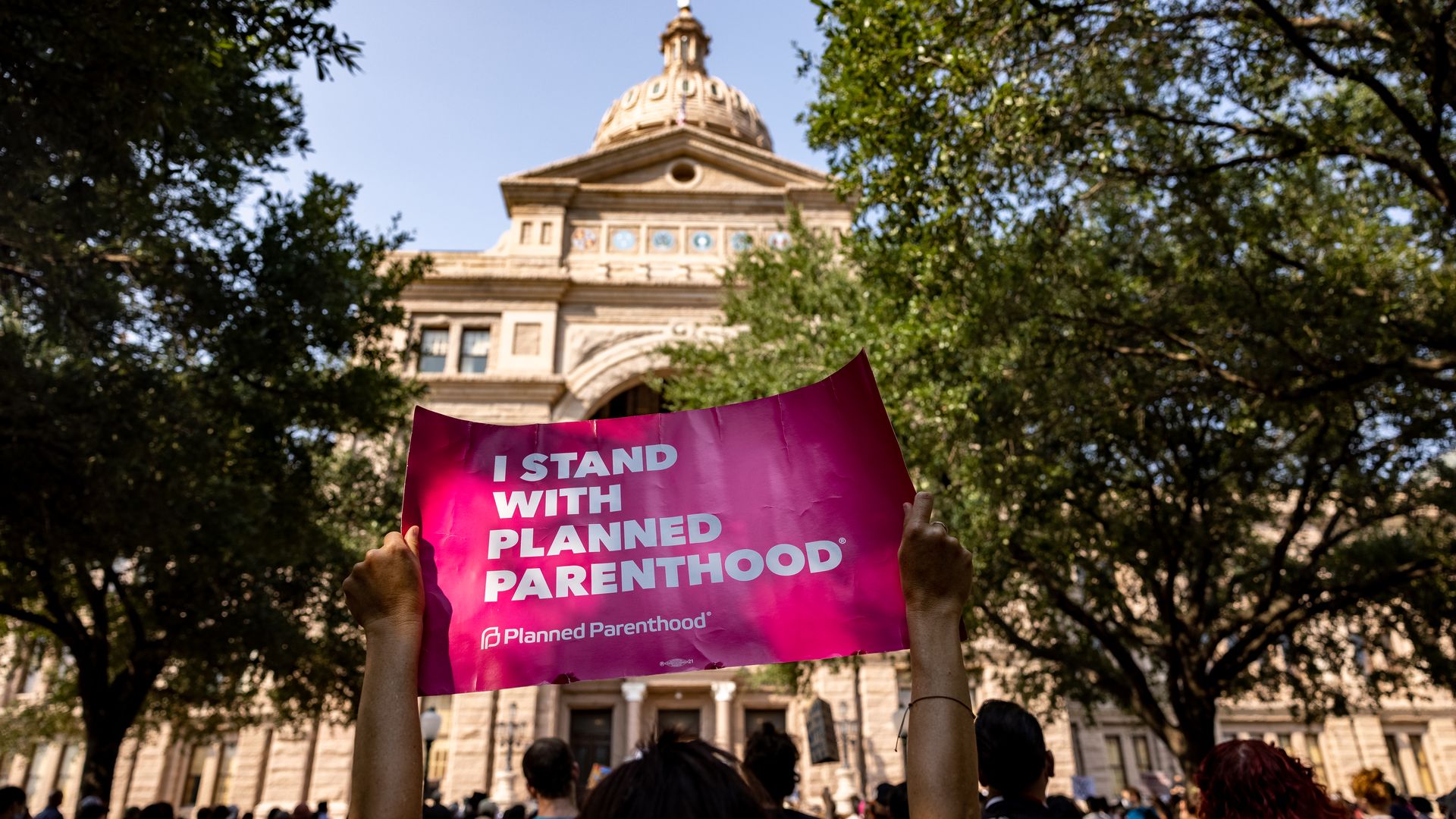 A protester holds a "I stand with Planned Parenthood" sign at a rally outside the Texas Capitol